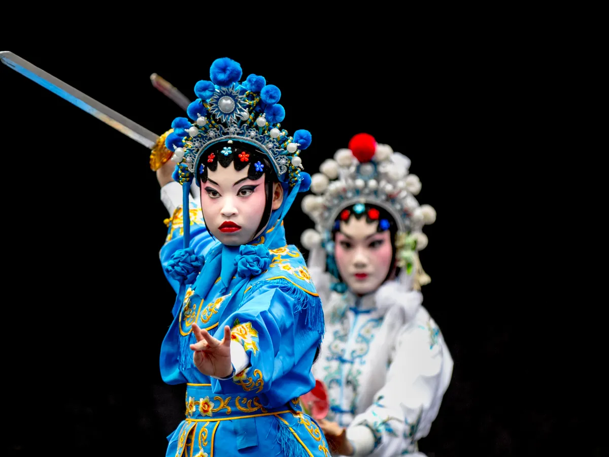 Chinese opera performers in stage costume holding swords