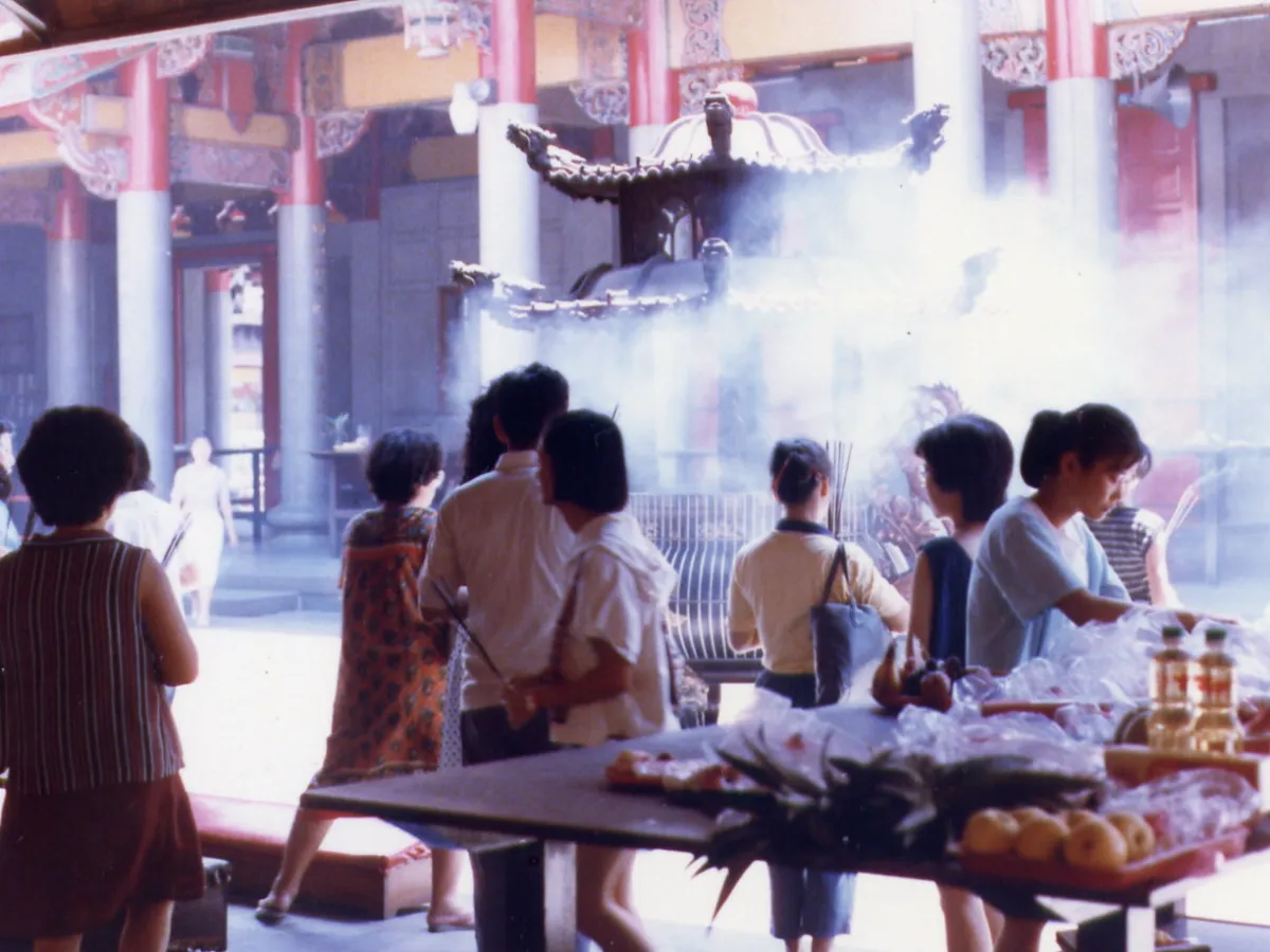People burning incense inside a Chinese temple