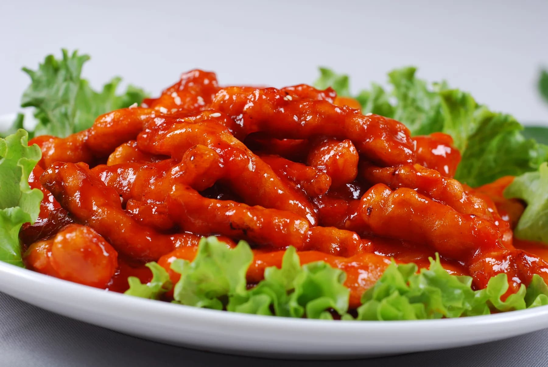 Chinese American food represented by a clean restaurant plate of glossy sweet and sour pork