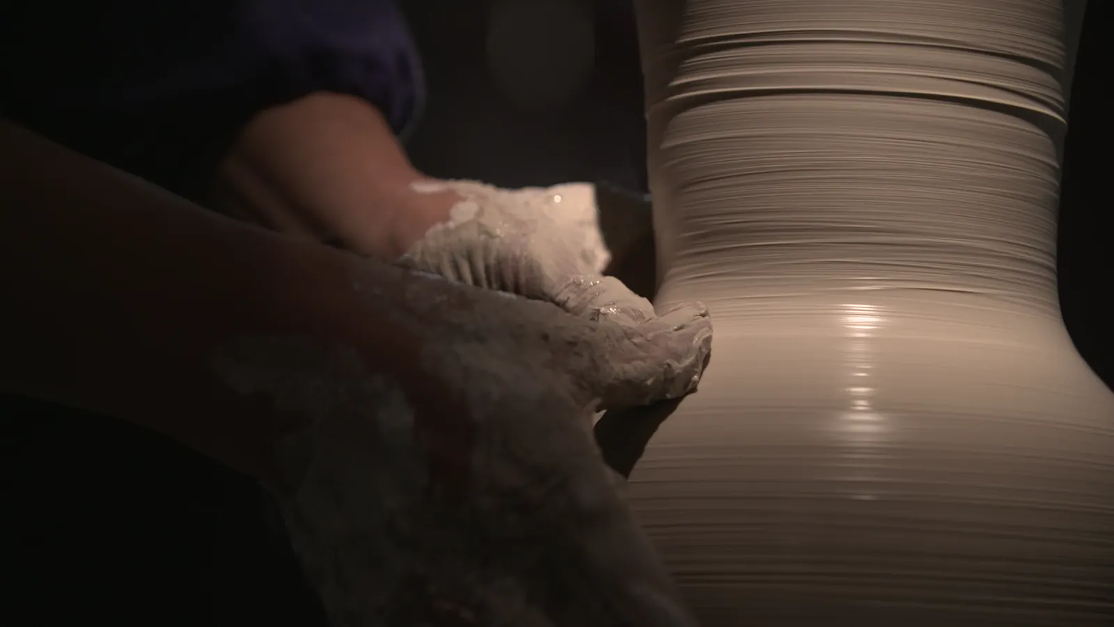 Chinese ceramics being formed on a potter's wheel as wet clay rises into a vessel