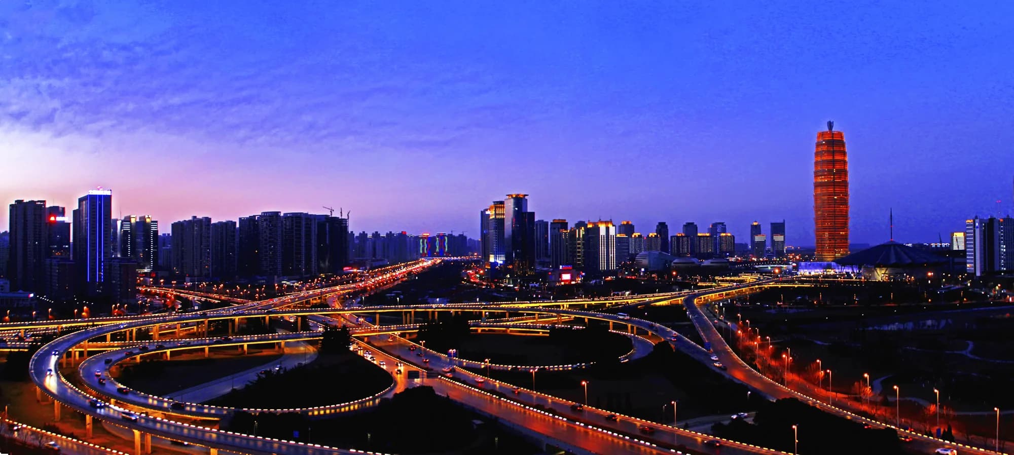 Panoramic view of Zhengzhou at dusk with roads, modern buildings and the Zhengdong skyline