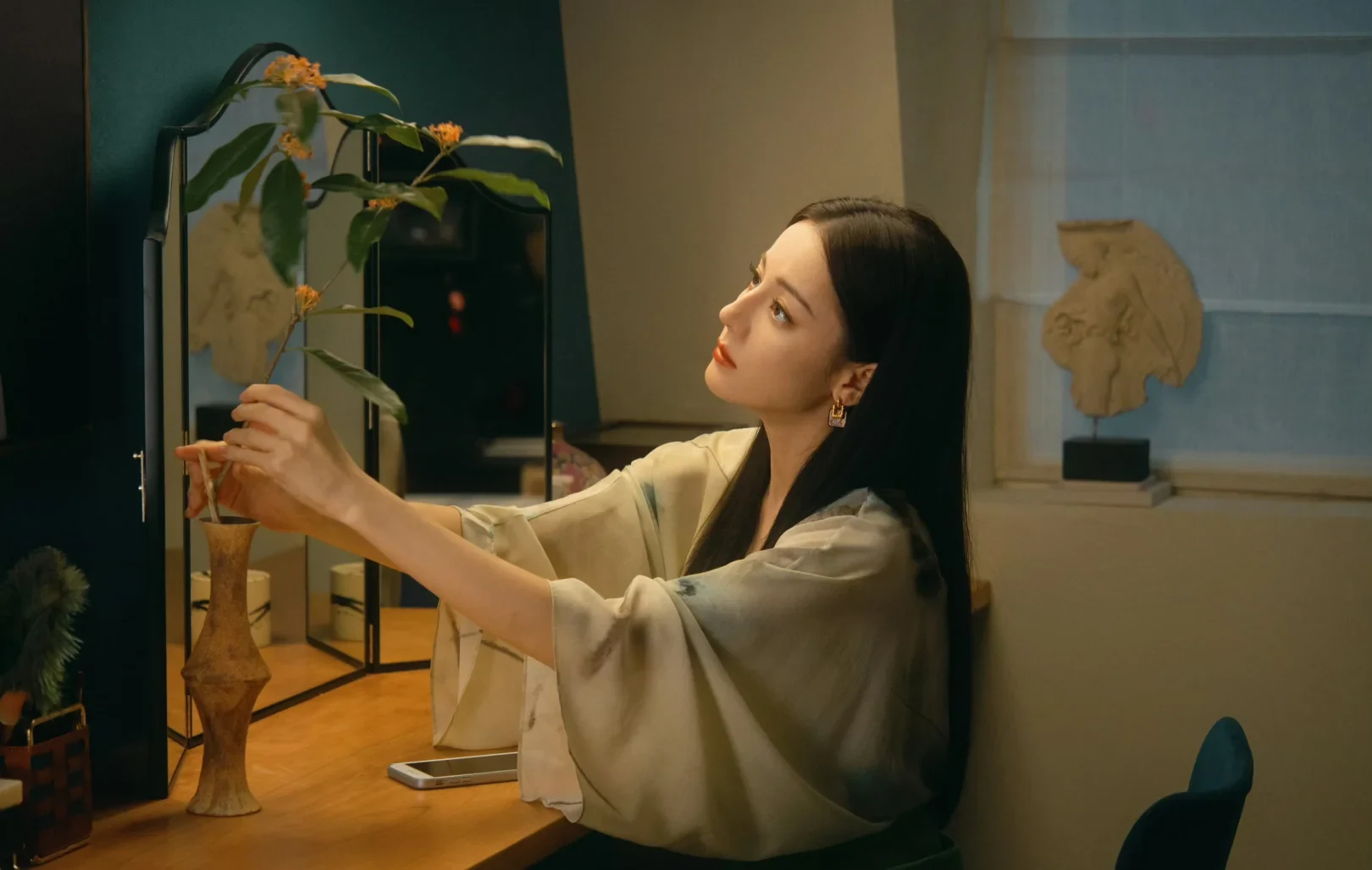 Dilraba Dilmurat as Nie Jiuluo arranging a flower at home in Love on the Turquoise Land