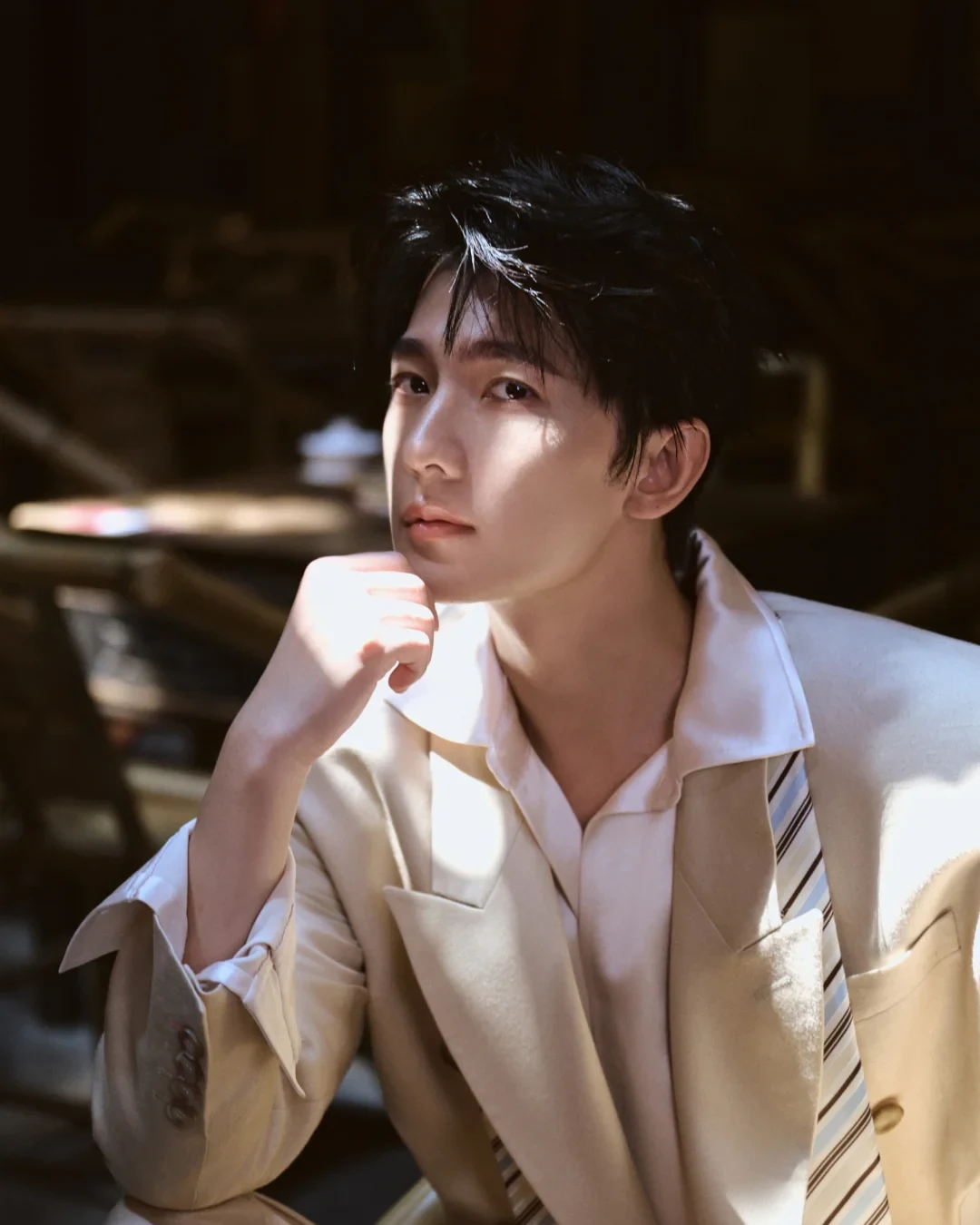 Yang Yang in a pale suit photographed inside a Chengdu tea-house setting in 2026