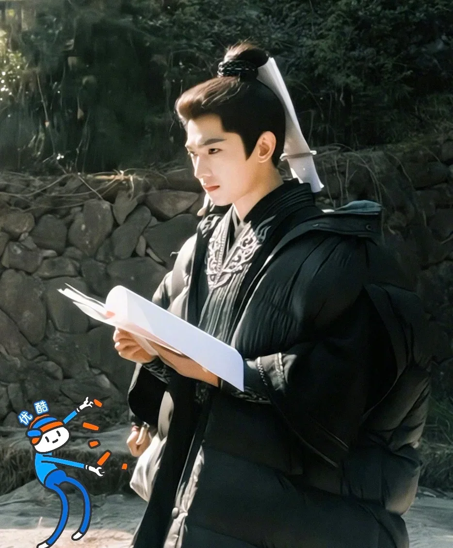 Yang Yang reading a script in costume on the set of A Record of a Mortal's Journey to Immortality