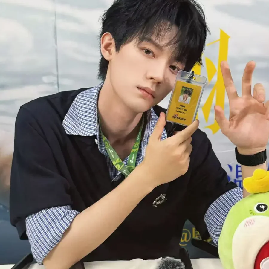Zhou Yiran at a 2025 Reborn promotional event, holding his event pass rather than performing a character