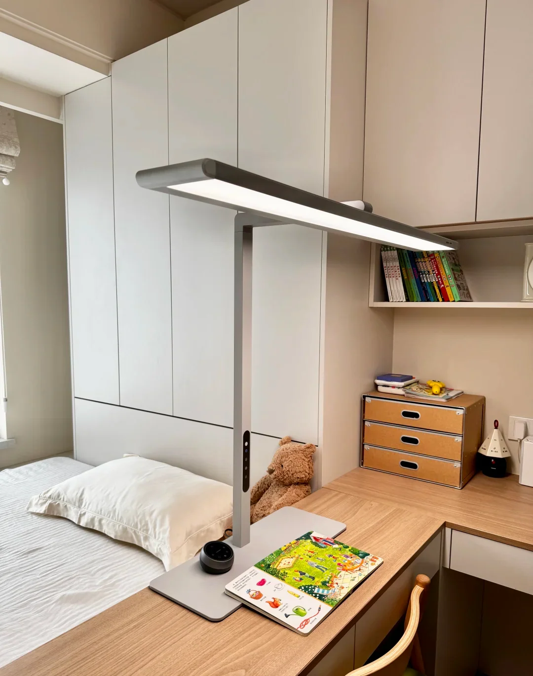 A compact bedroom where the bed, desk, window and full-height storage share one tight plan