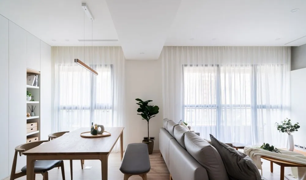 A bright lived-in living and dining room with clear zones, windows and an open walking route