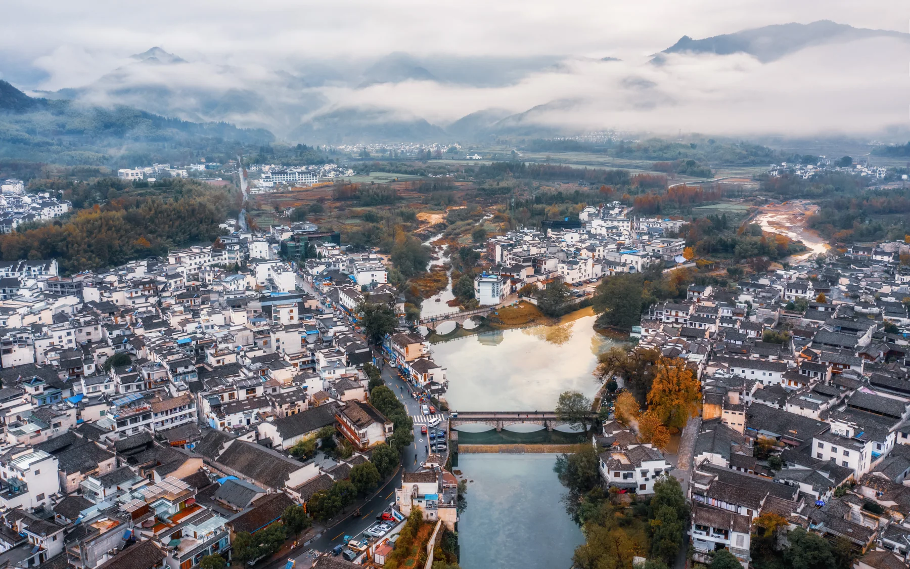 Aerial view of Hongcun showing a village fitted between water, fields and mountain terrain