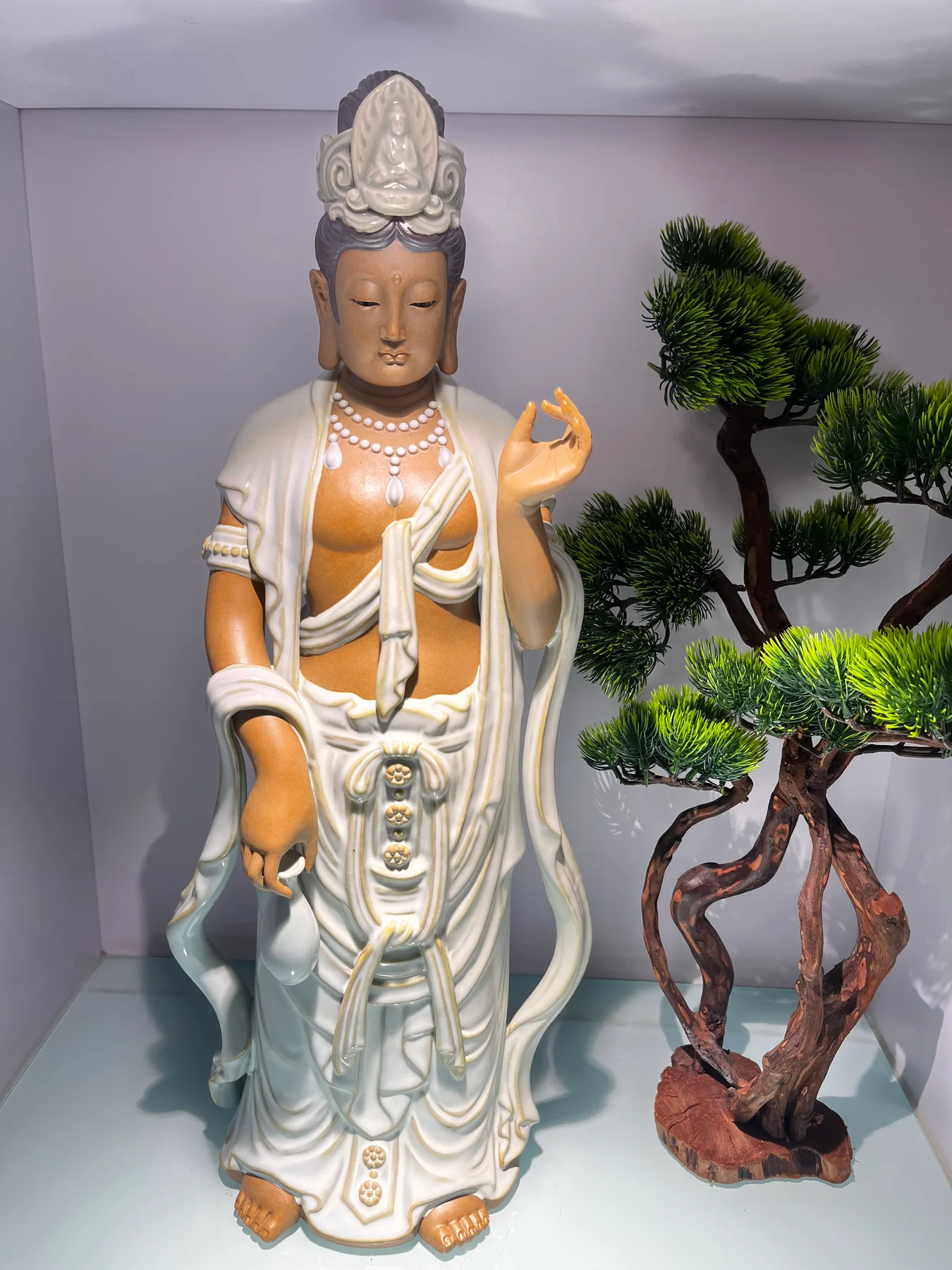 Ceramic figure in the Culture Park display, with separate hands and layered folds projecting from the body