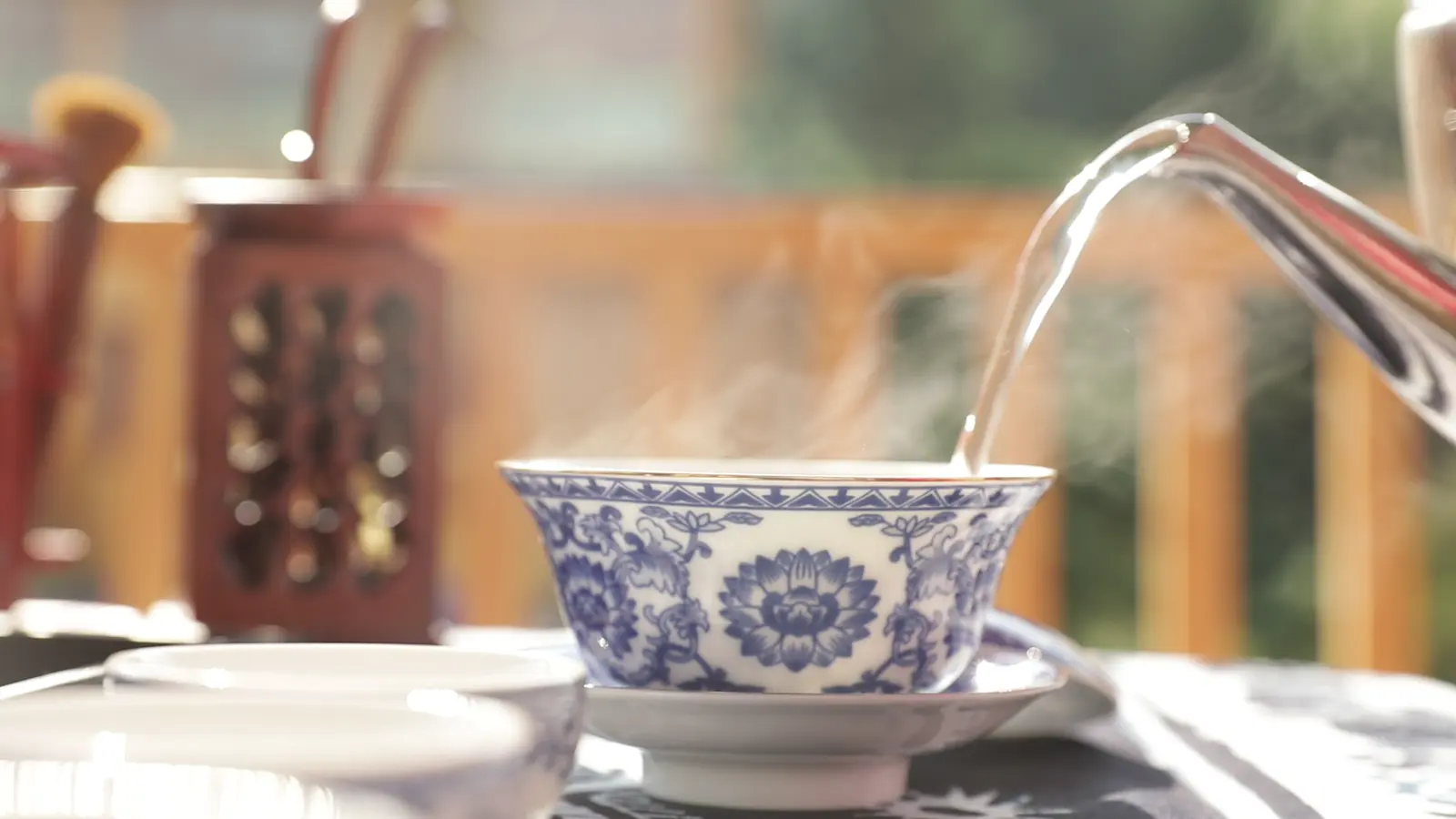Hot water entering a blue-and-white tea bowl, showing Chinese ceramics as objects of daily use