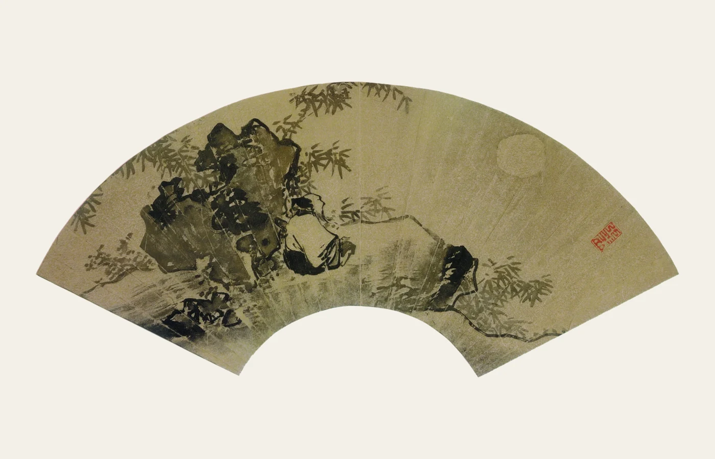 A fan-shaped Chinese landscape painting with figures, trees and a moon composed across the curved leaf