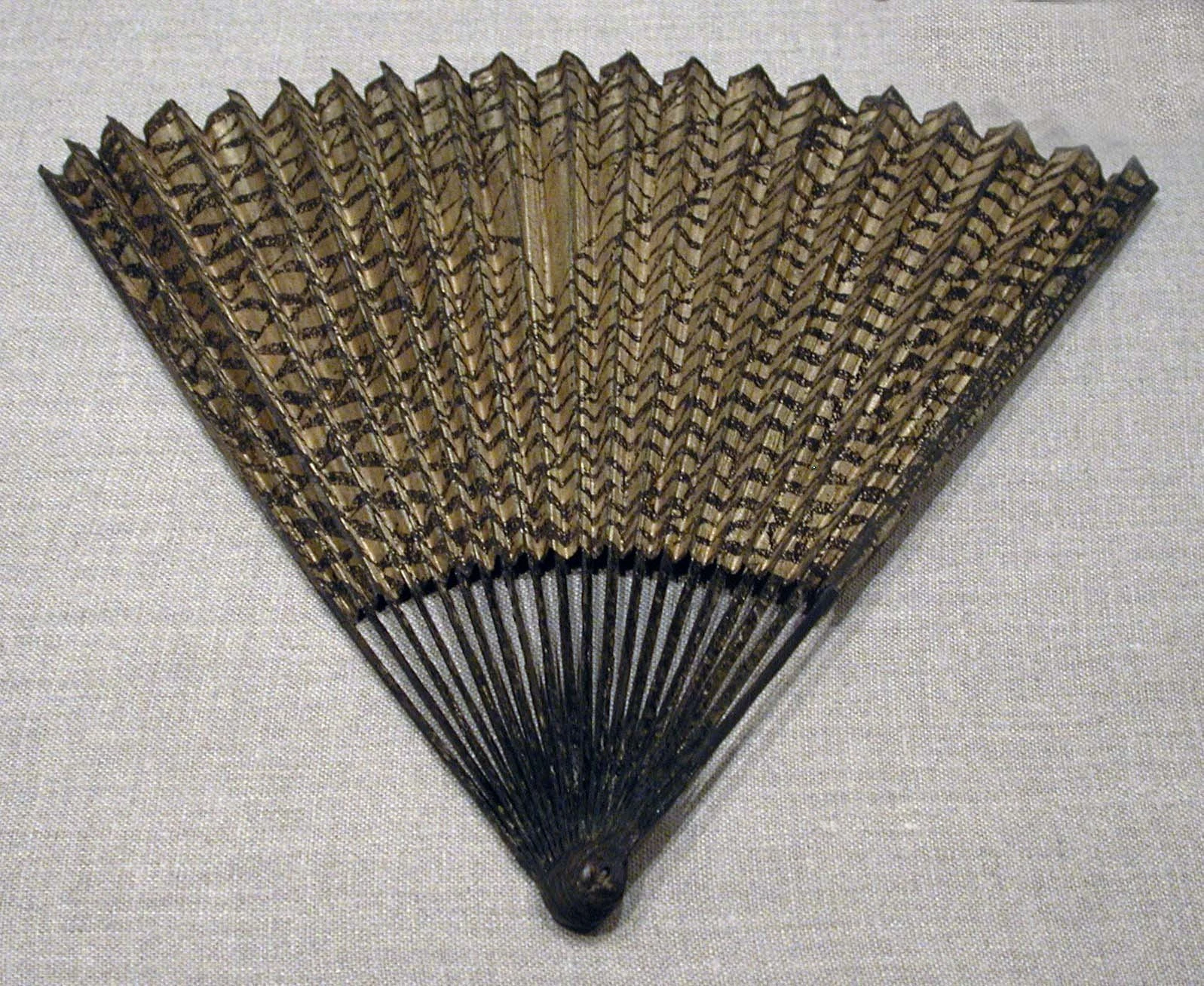 Complete Chinese folding fan with gold-flecked paper, decorated bamboo ribs and a shared pivot
