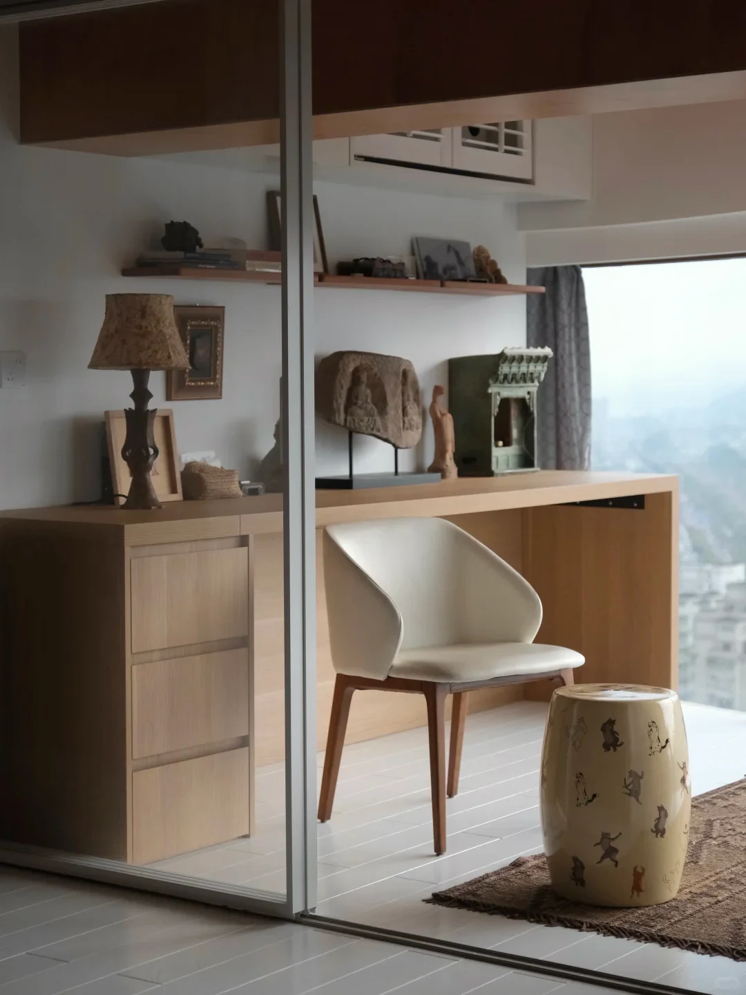 Cat-painted contemporary ceramic drum stool beside a white chair and wooden desk