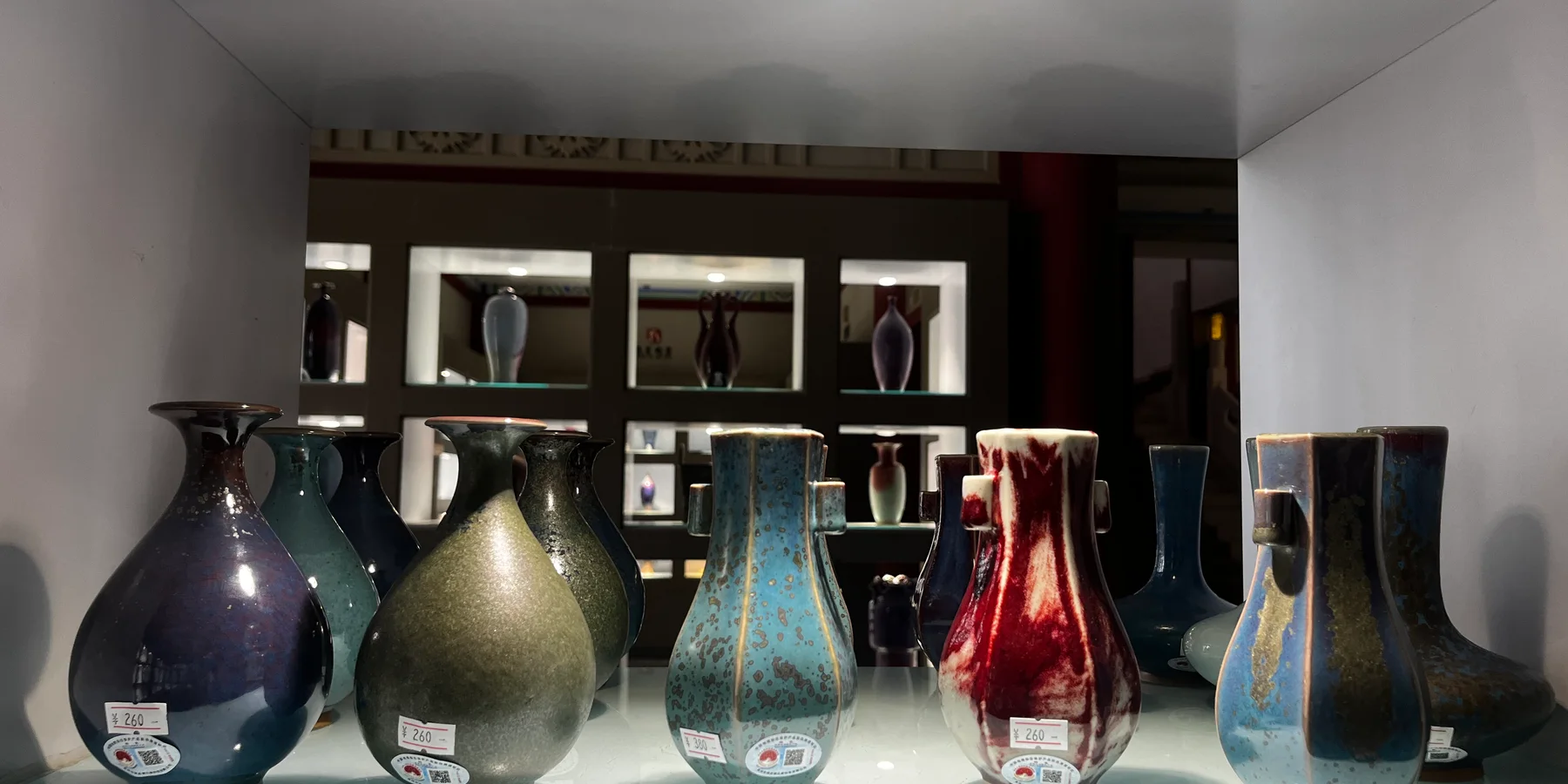 A real ceramics display with pear-shaped, angular and handled glazed vases in a Jun ceramic culture park