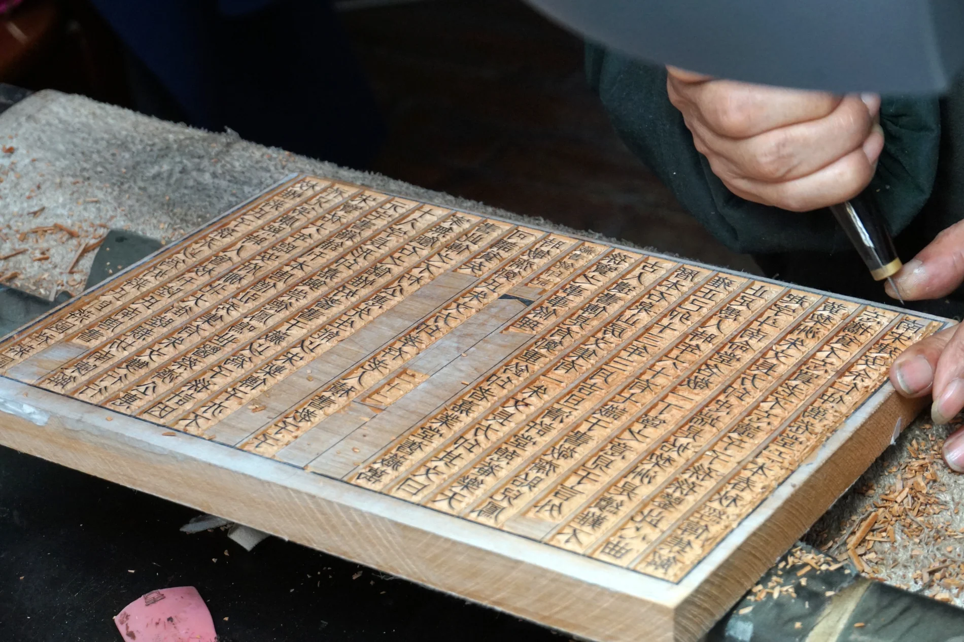 A block-carving demonstrator cutting dense reversed lines at the Yangzhou China Block Printing Museum