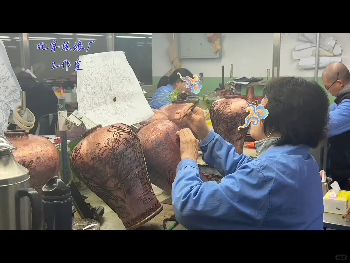 Workers shaping wire decoration on copper vessels beside a floral drawing in a Beijing enamel workshop