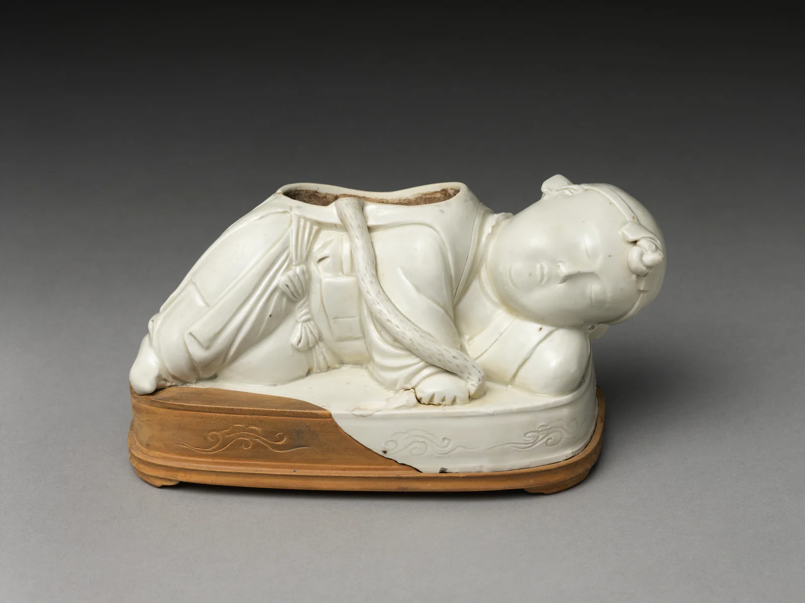 Ding ware pillow base modeled as a reclining boy, an expressive alternative to the idea that Song ceramics were only plain bowls