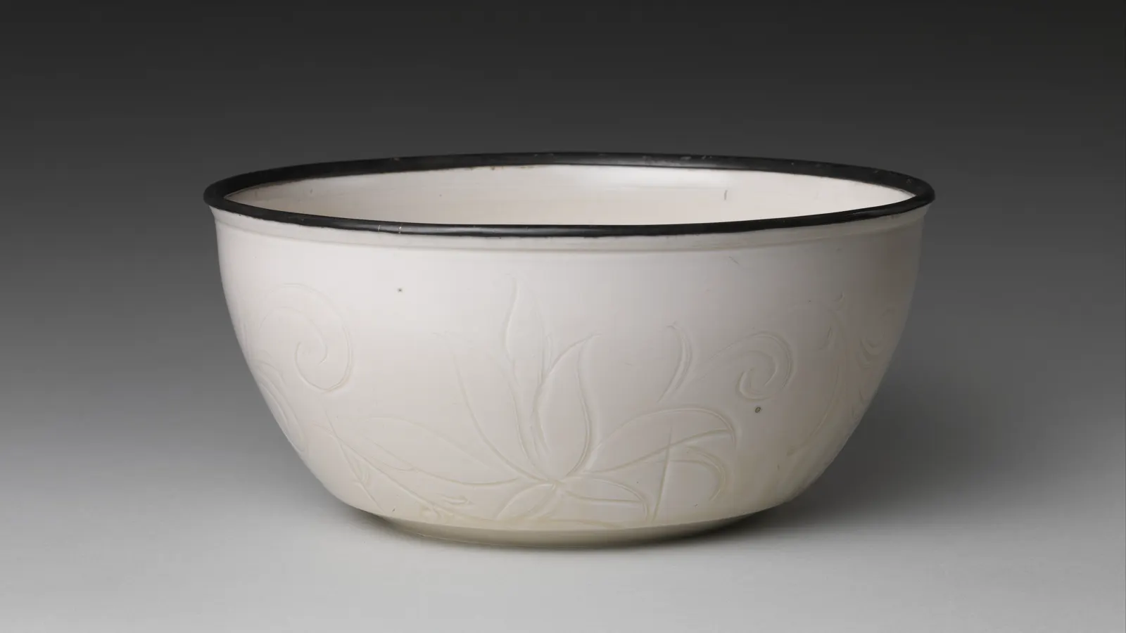Ding ware basin with carved and incised lotus decoration spreading across the interior