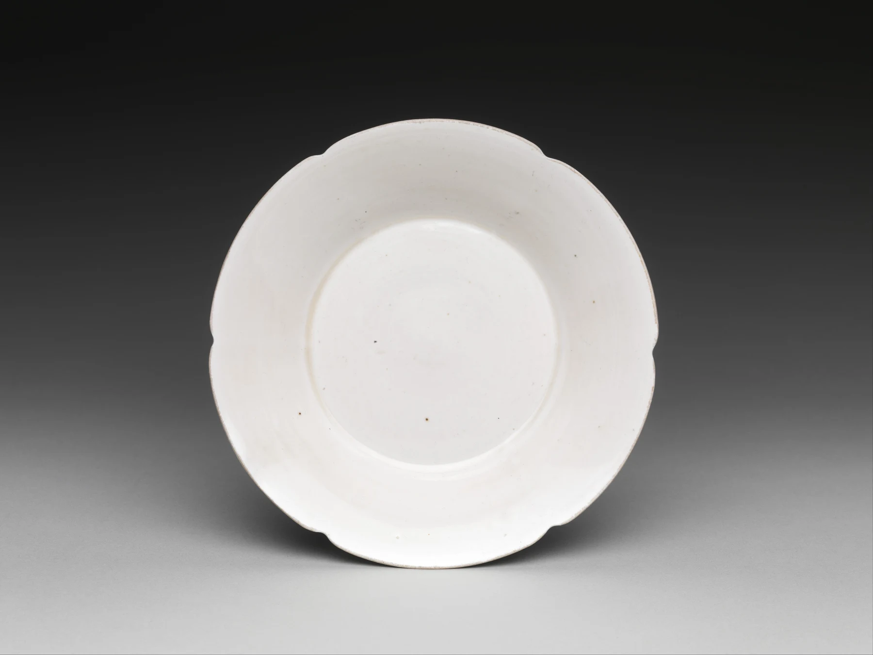 Eleventh-century Ding ware porcelain dish with an ivory glaze and scalloped rim