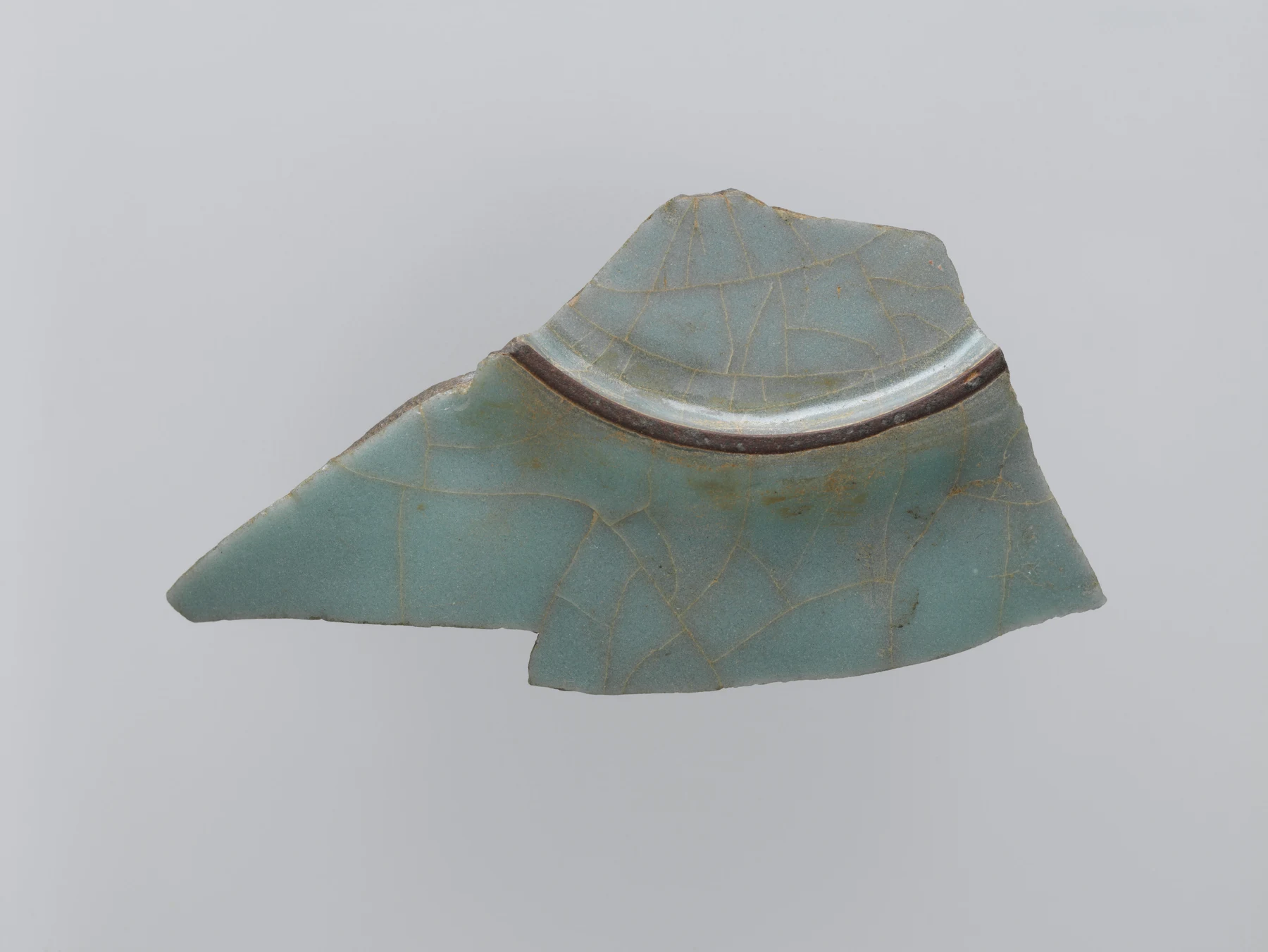 Guan ware sherd showing a broken glazed wall and part of an exposed foot ring