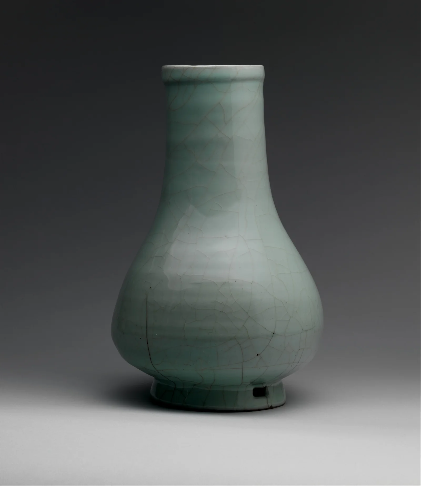 Full profile of a Guan ware vase, showing its neck, swelling body and foot beneath crackled celadon glaze