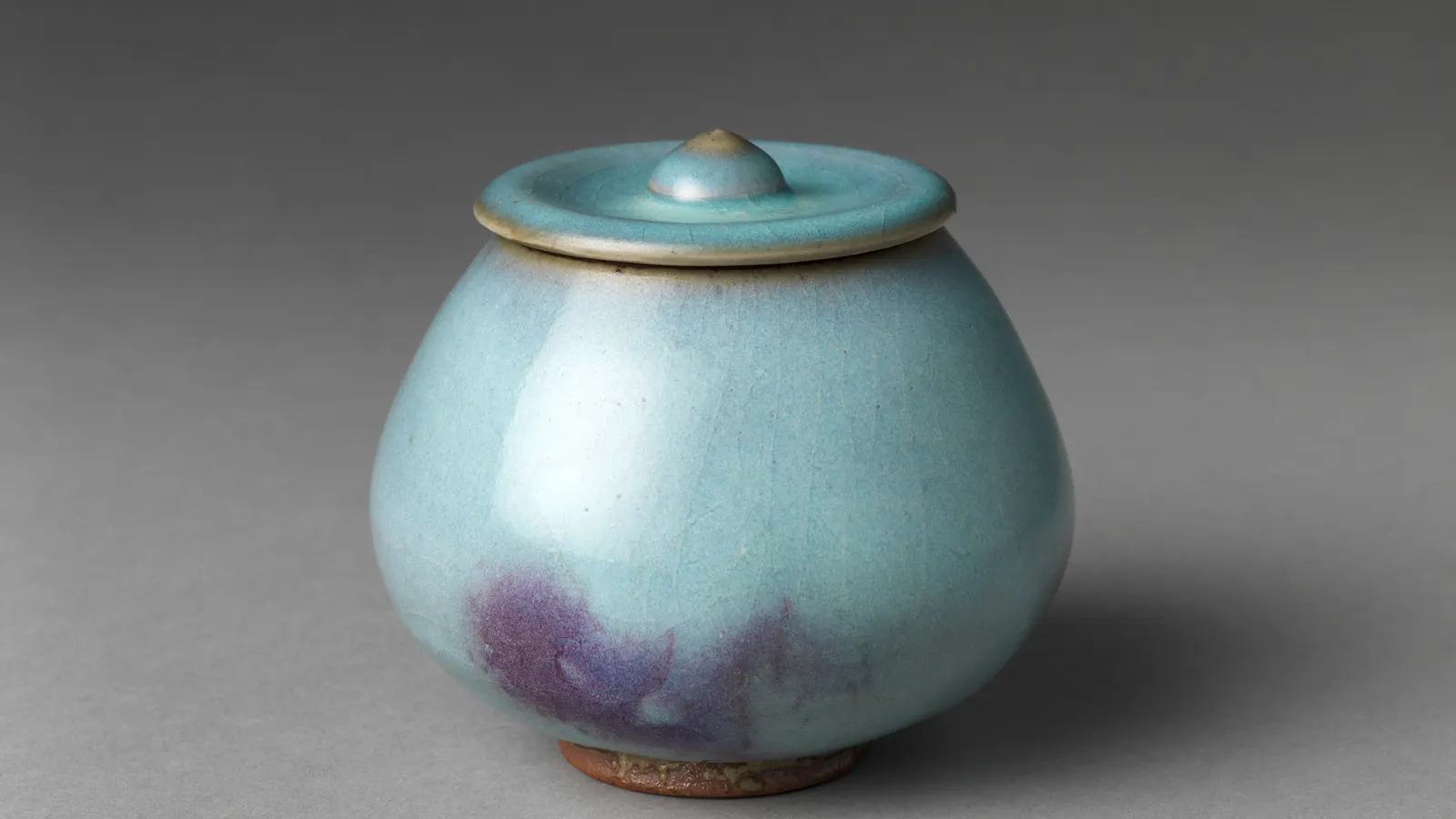 Jun ware jar with a blue glaze interrupted by an irregular purple-red splash
