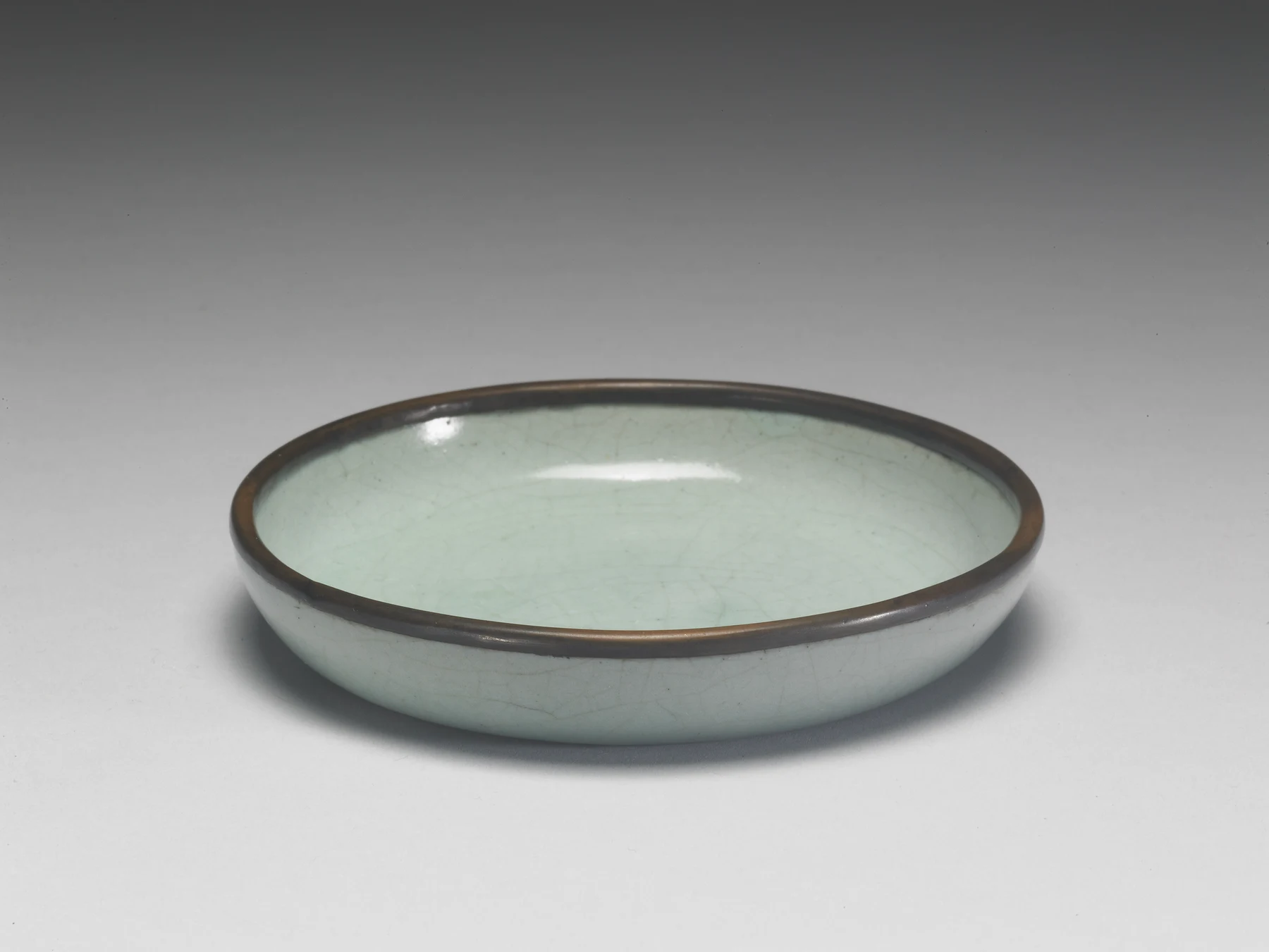 Front view of a Northern Song Ru ware celadon washer with a shallow curved wall and metal-bound rim