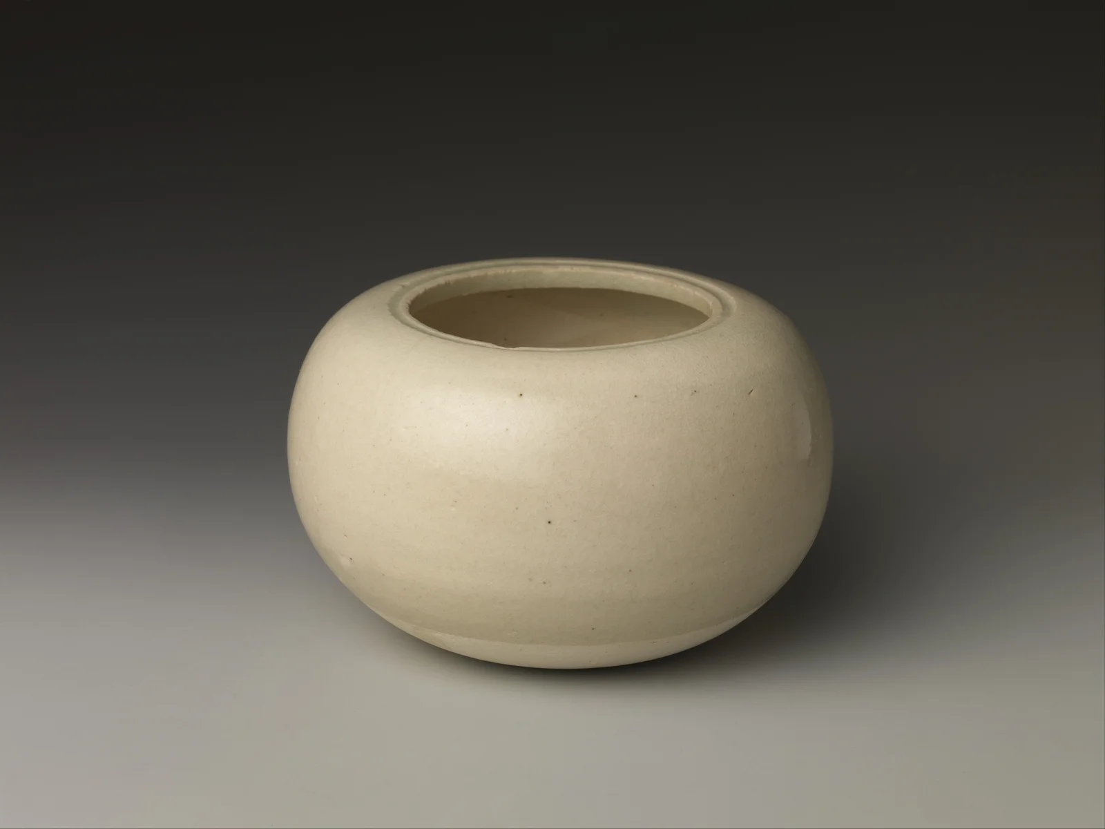 Seventh-century Chinese white-glazed porcelain bowl with a rounded body and inward-turning rim