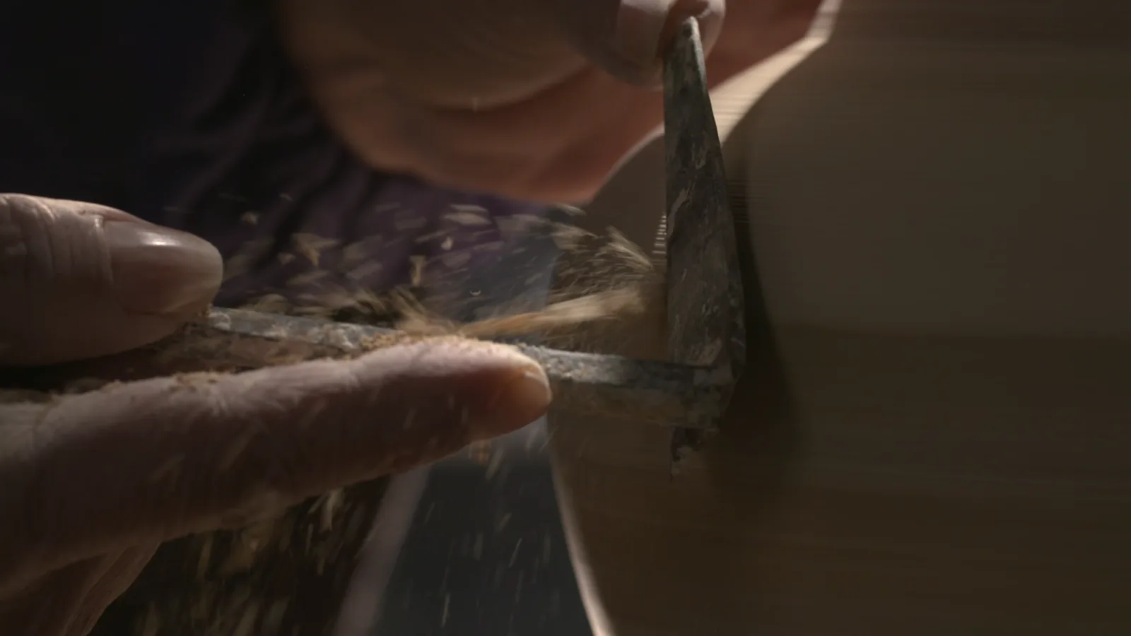 A metal tool refining the lower wall and foot of a leather-hard porcelain vessel
