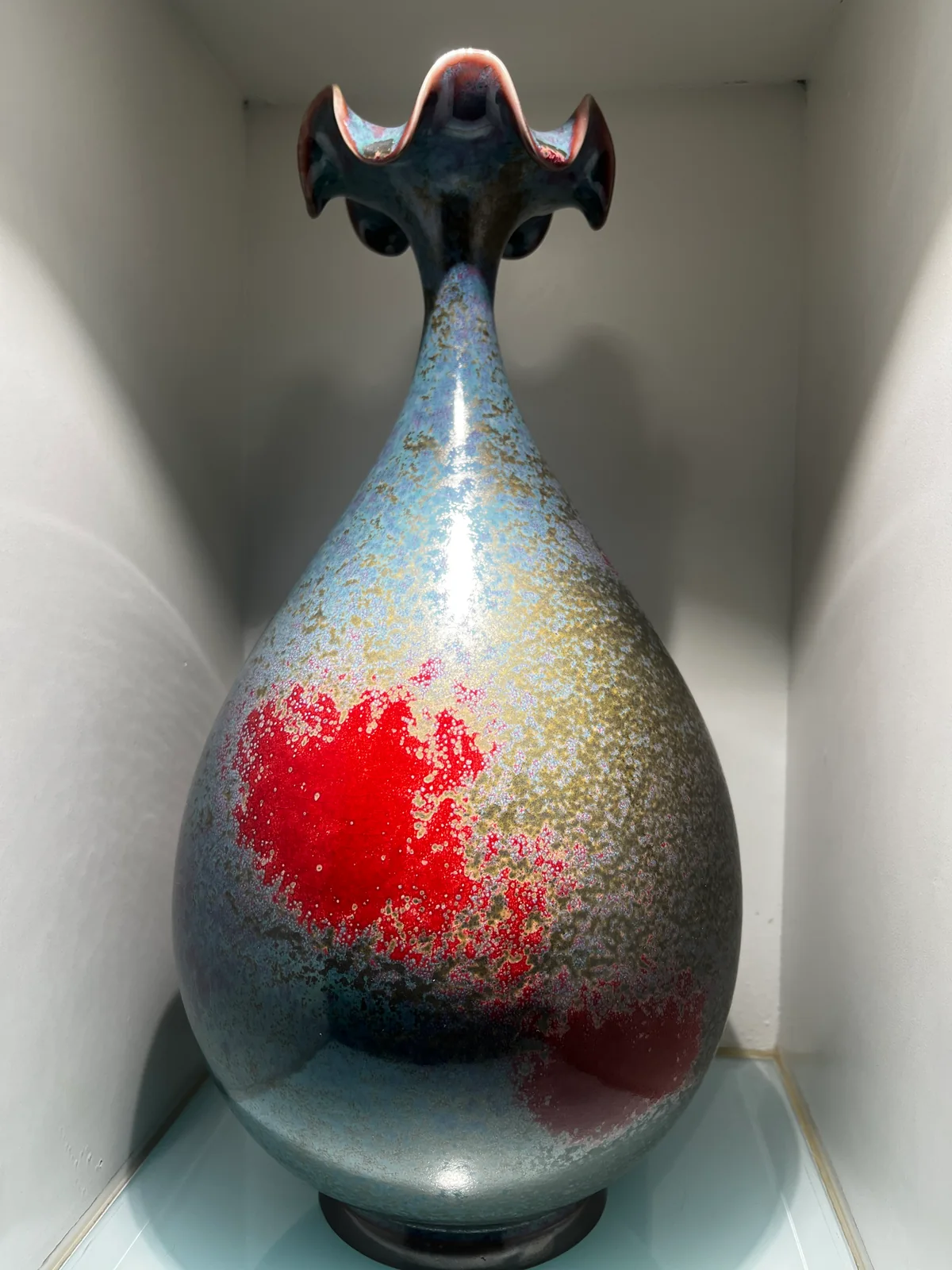 A contemporary tall Jun-style vase with a vivid red field dissolving into blue-gray glaze