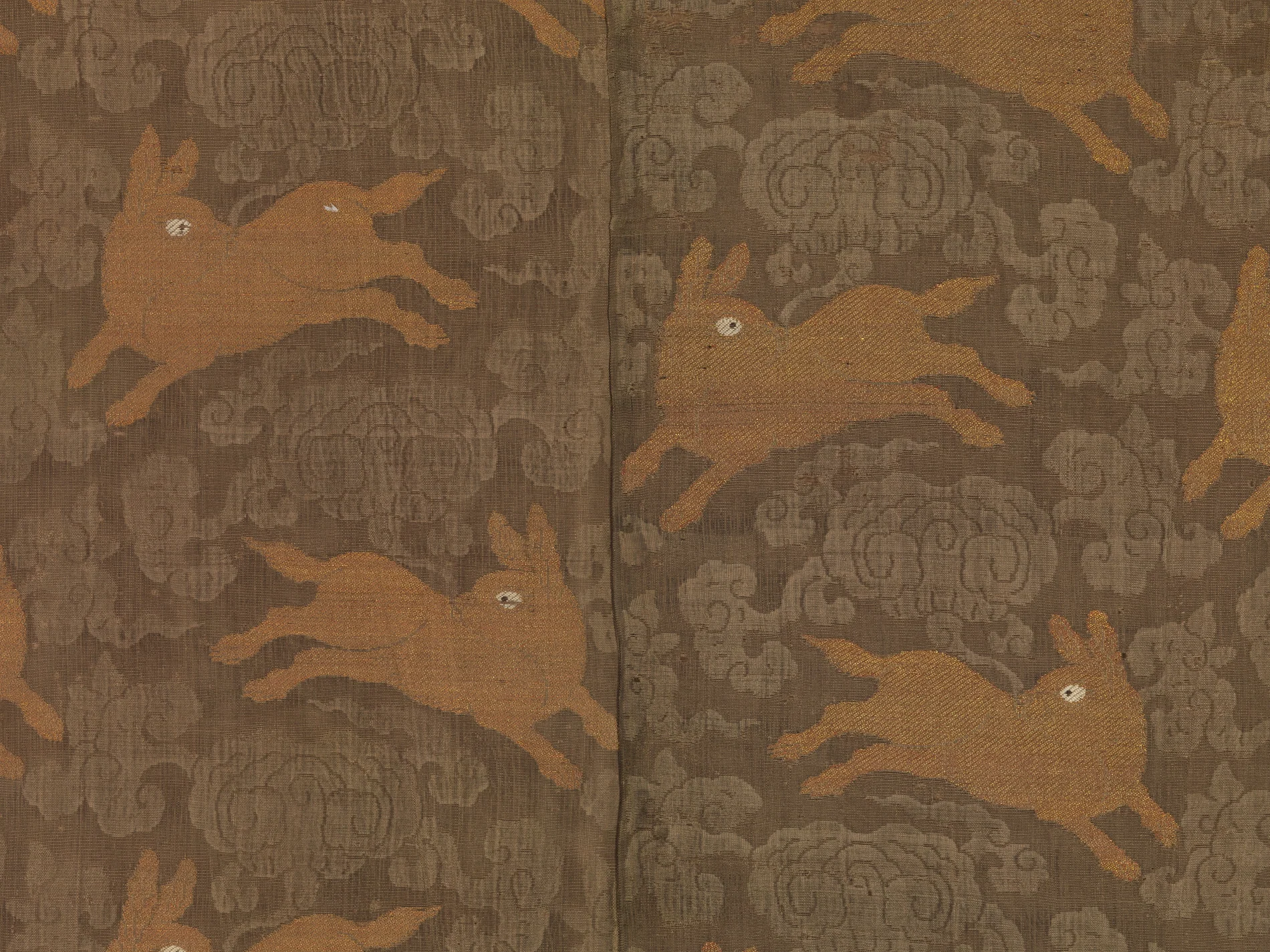 Close detail of Ming silk gauze with gold rabbits running across a woven cloud field