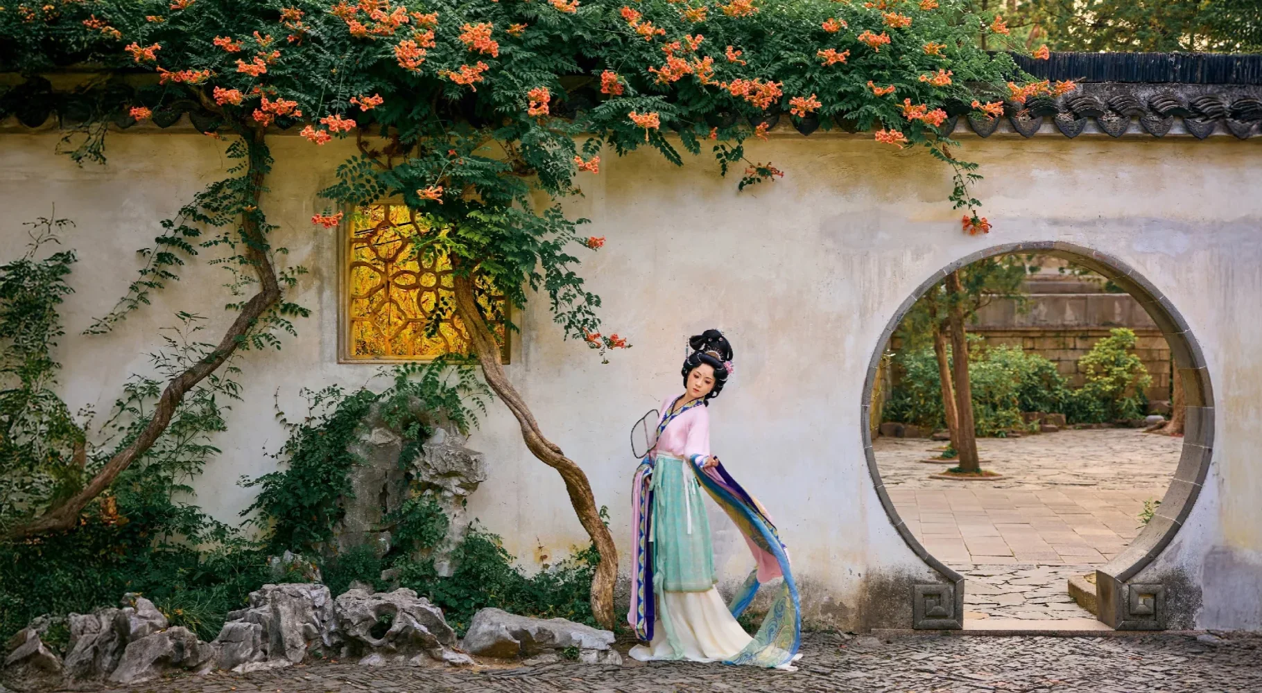 Contemporary Hanfu wearer showing a complete layered silhouette beside a moon gate in a Chinese garden