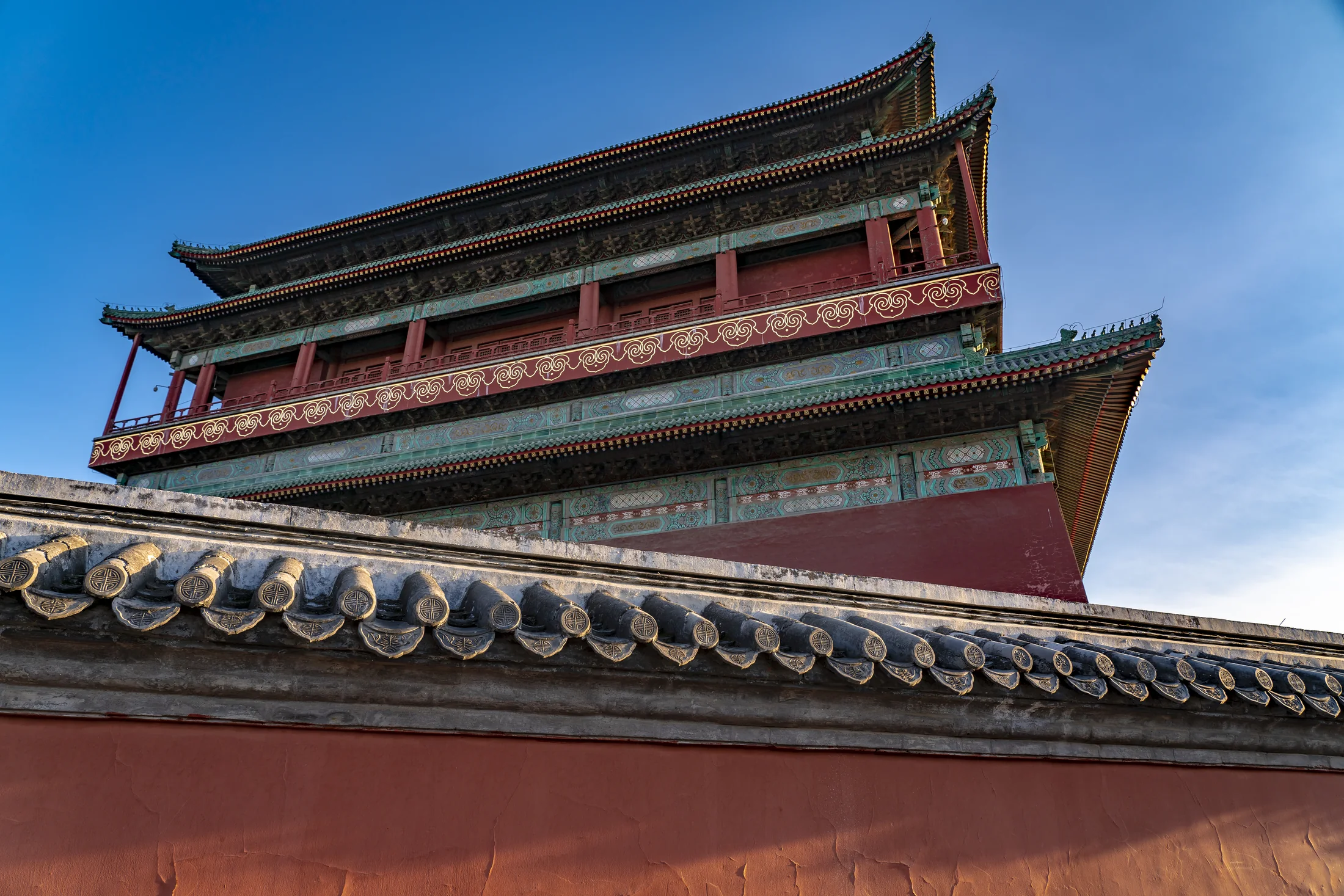 Beijing Drum Tower rising above gray roof tiles near the city's historic hutong neighborhoods
