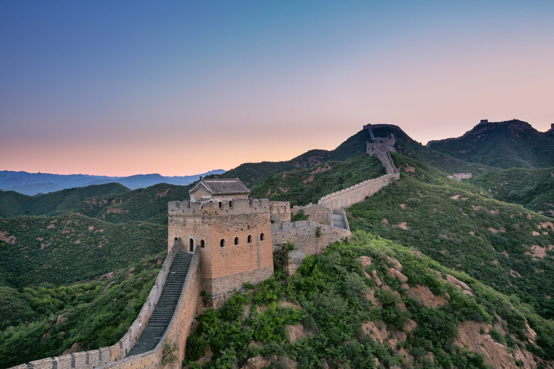 The Great Wall near Beijing following a green mountain ridge between watchtowers