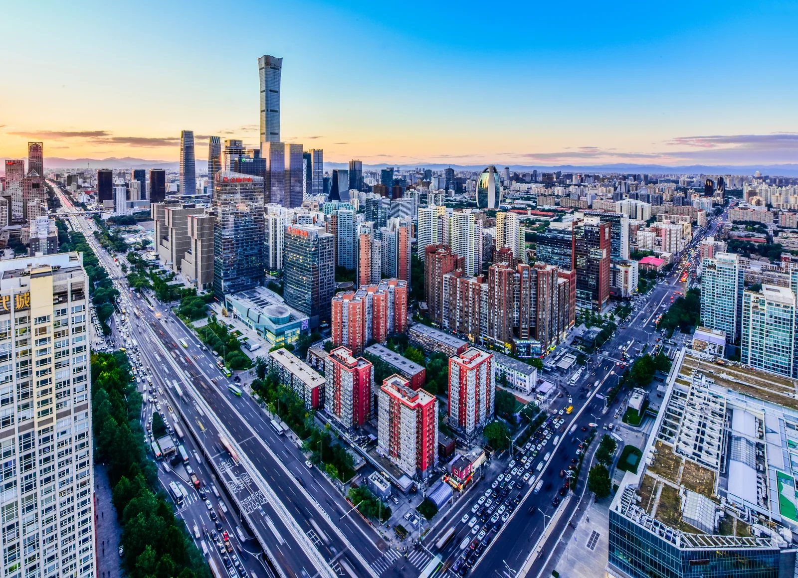 Modern Beijing skyline beyond a broad avenue, showing the metropolitan scale outside the historic core