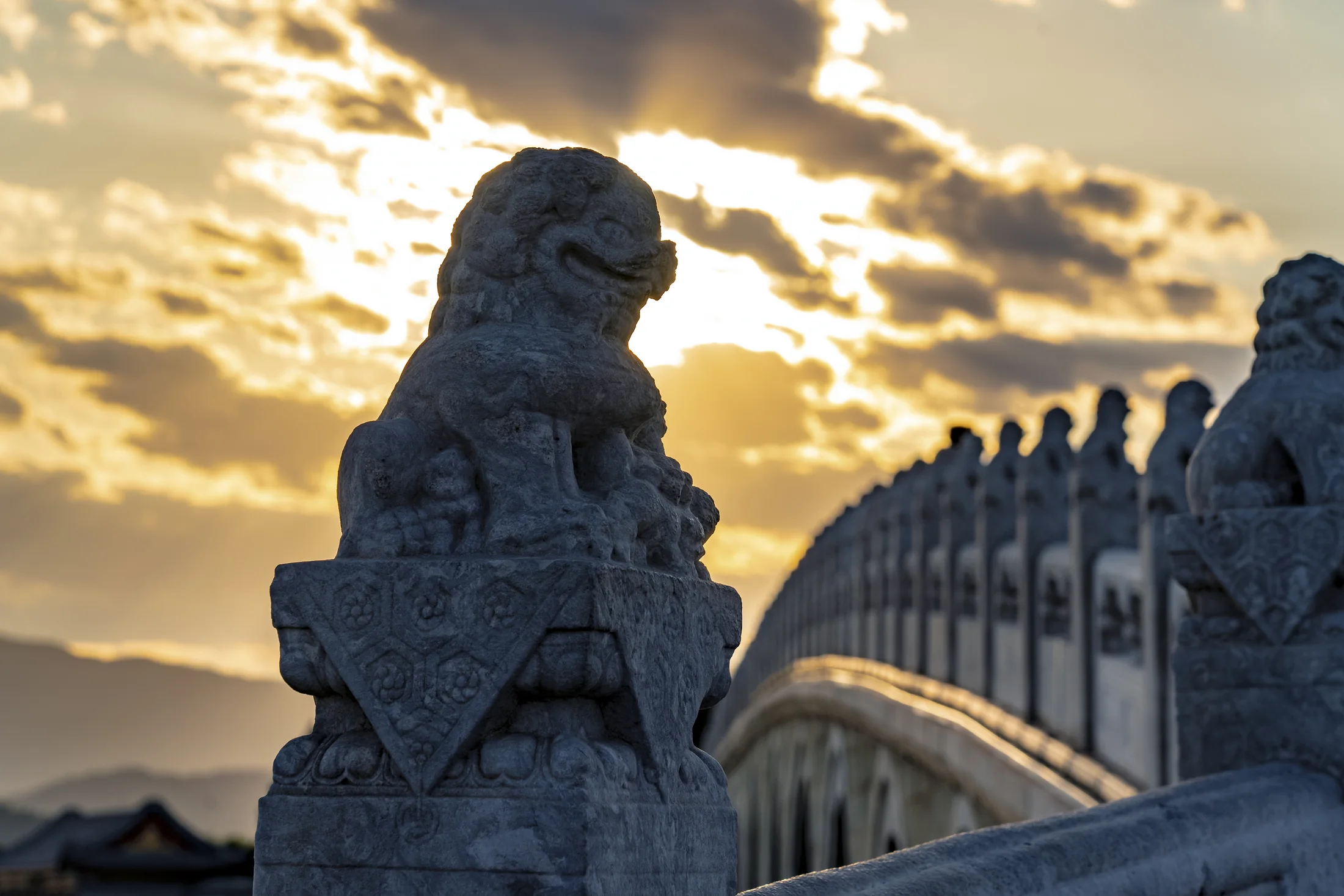 The Seventeen-Arch Bridge at Beijing's Summer Palace silhouetted against warm evening light