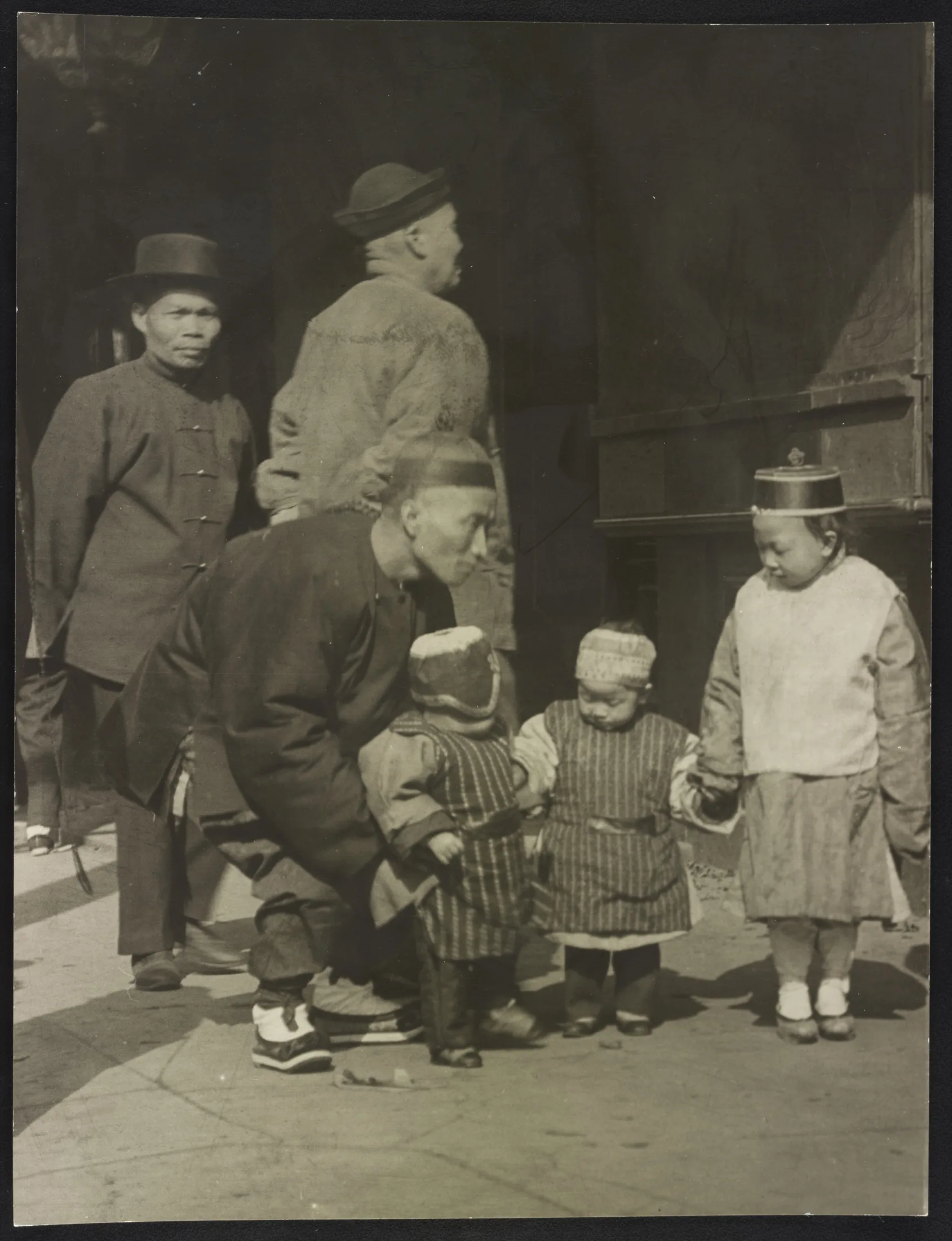 Chinese American men and children standing together on a Chinatown street in San Francisco between 1896 and 1911