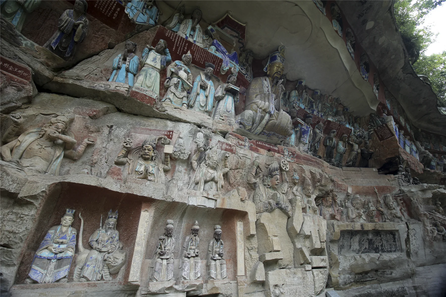 Figures and narrative scenes carved into a cliff at the Dazu Rock Carvings