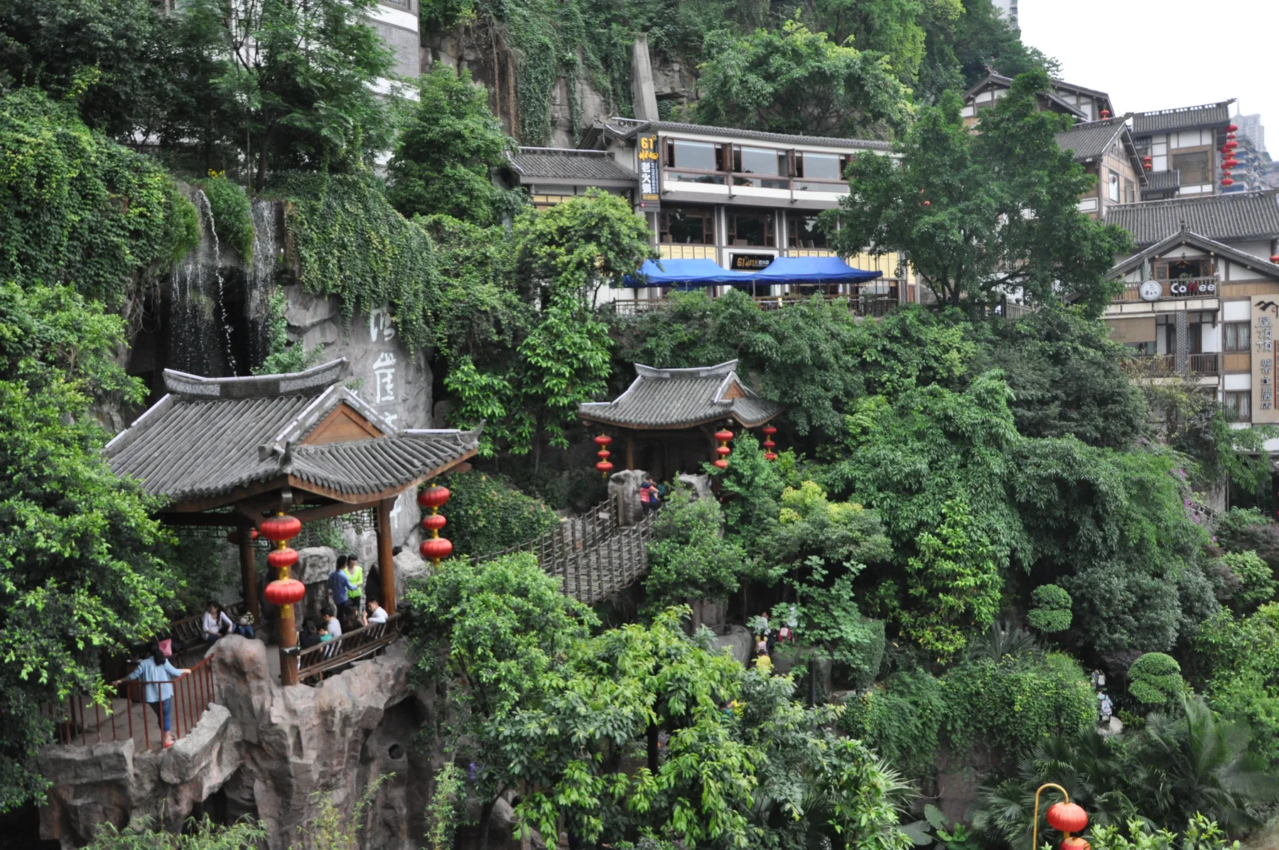 A steep Chongqing lane descending between hillside houses and vegetation