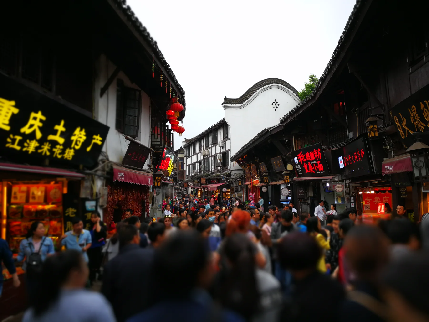 Visitors walking through a crowded historic commercial street in Chongqing
