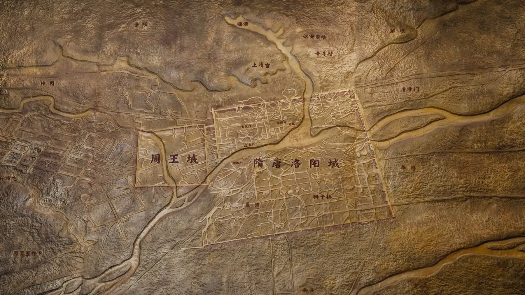 A carved museum relief maps the Zhou and Sui-Tang city plans around Luoyang
