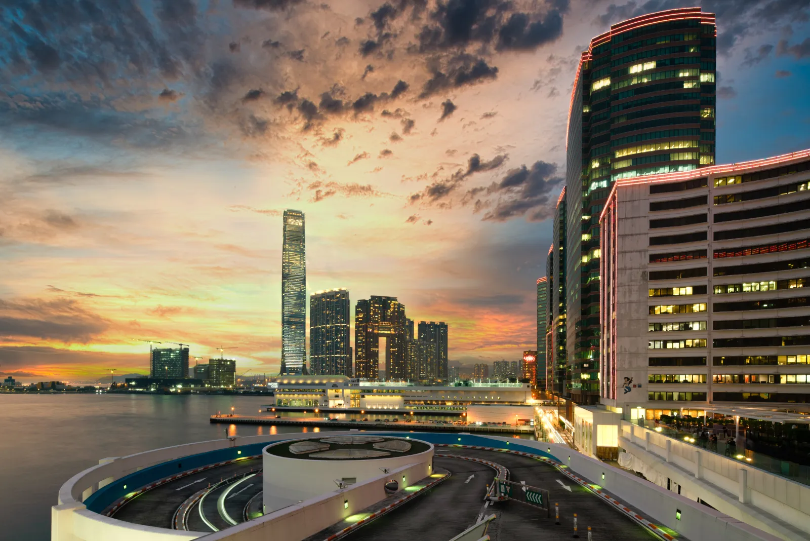 Kowloon waterfront architecture and the ICC tower beneath a dramatic sunset