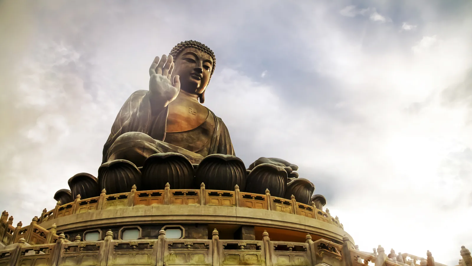 Tian Tan Buddha on Lantau Island seen from below against a cloudy sky