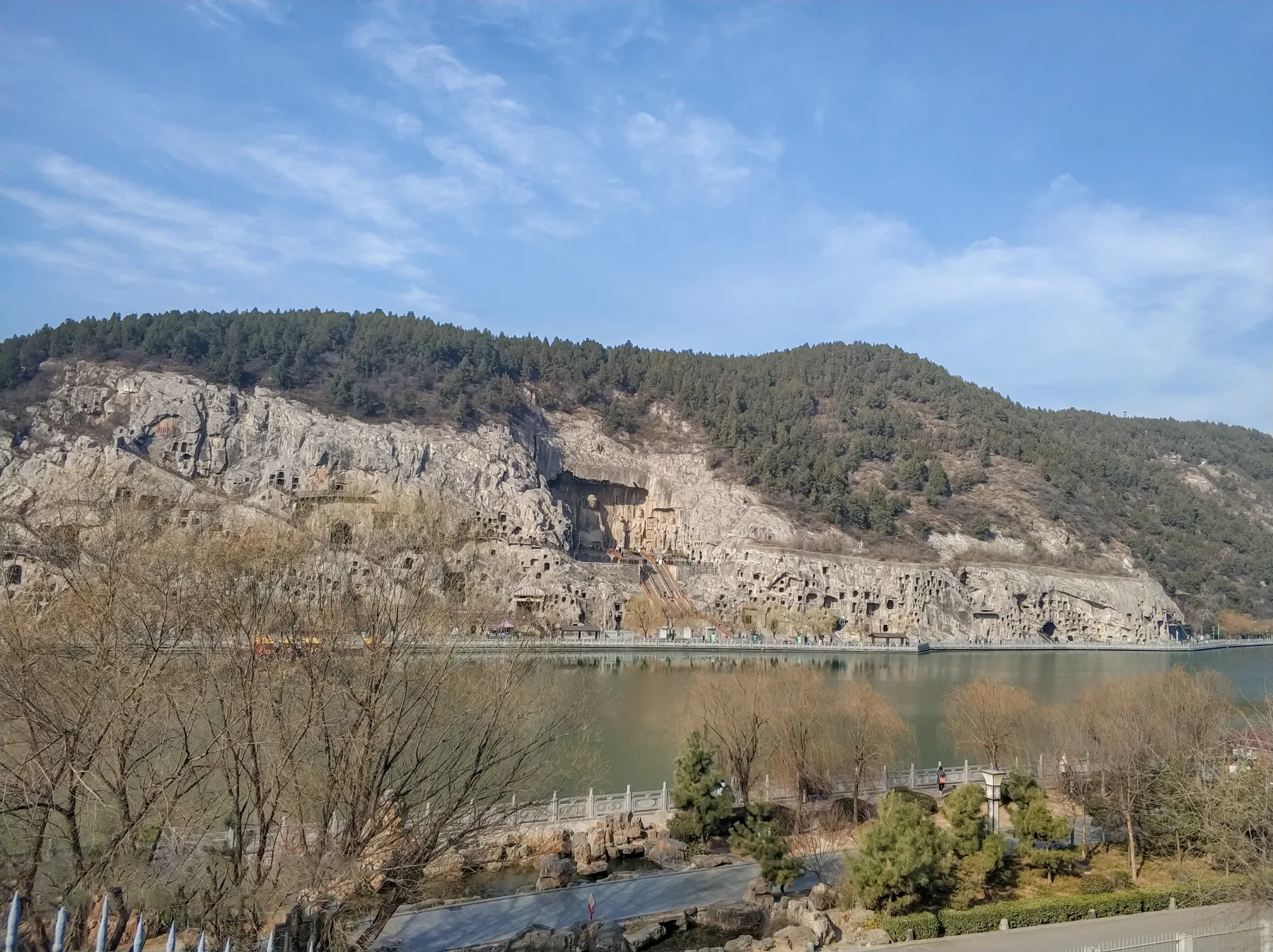 A broad view of caves and niches across the Longmen limestone cliff