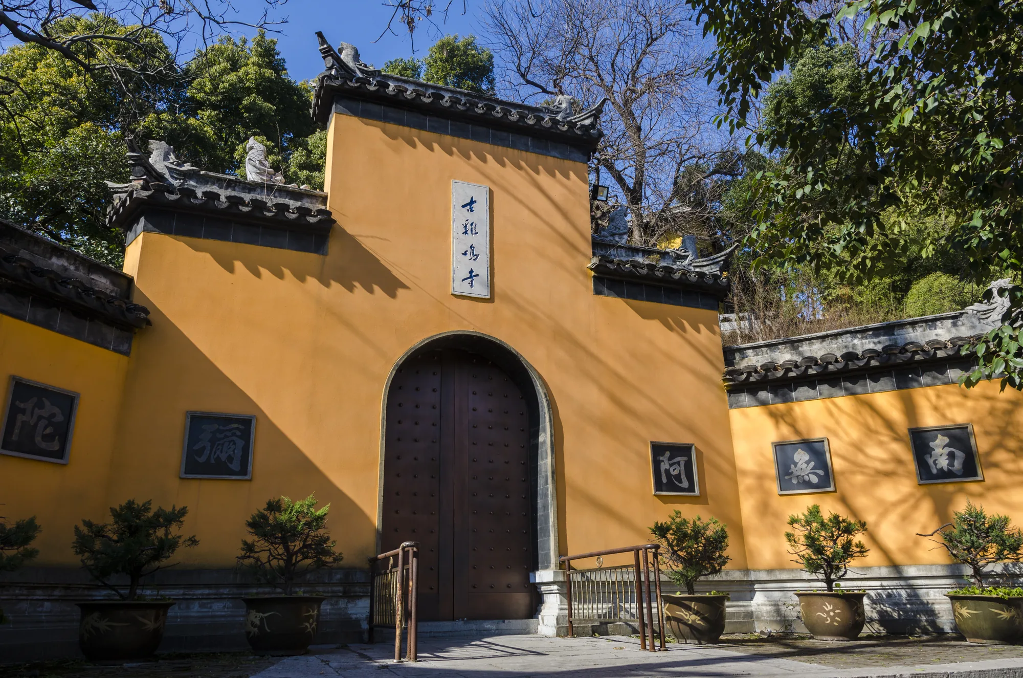 Yellow temple buildings and city greenery at Jiming Temple