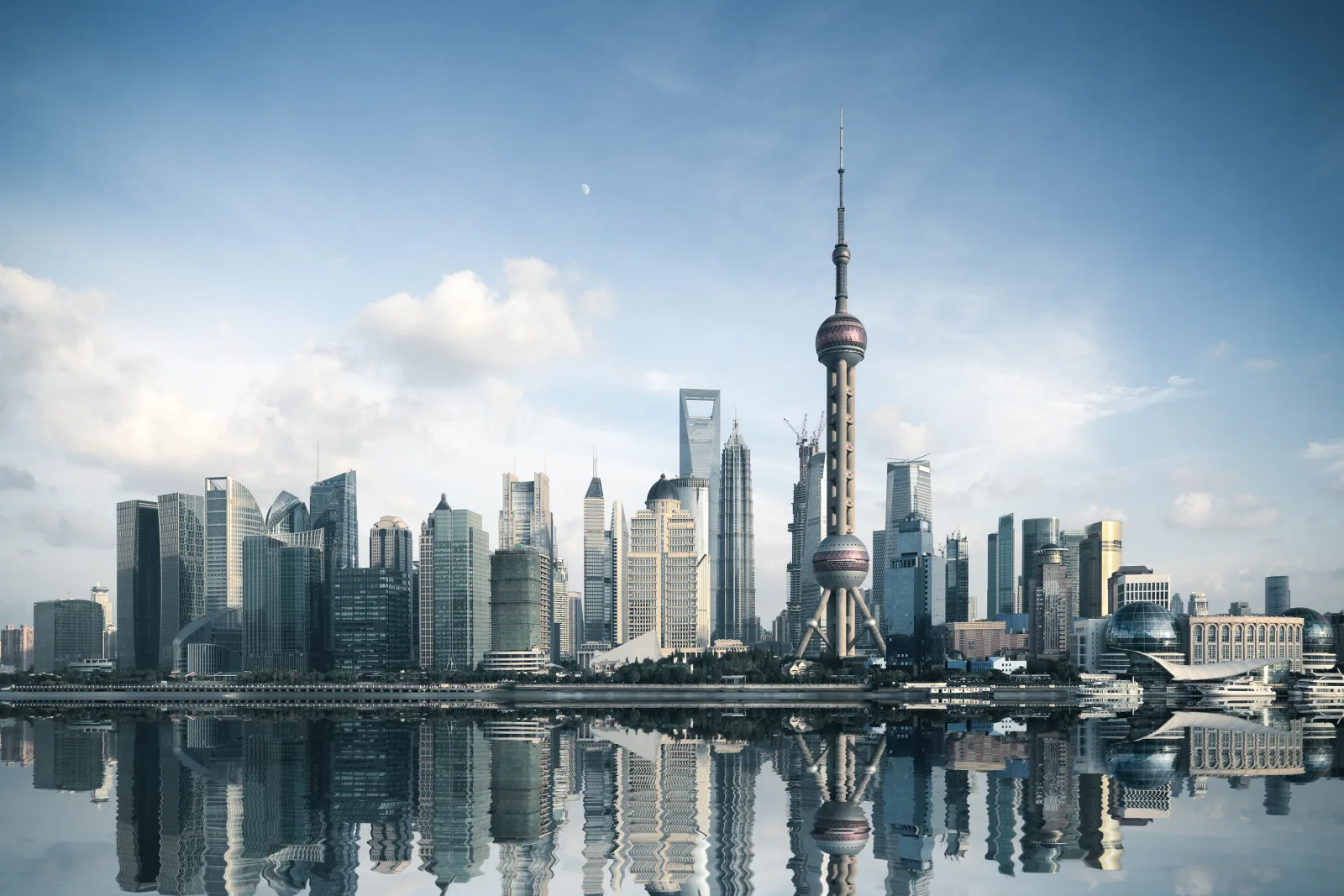 Pudong's modern Shanghai skyline reflected across the Huangpu River in daylight