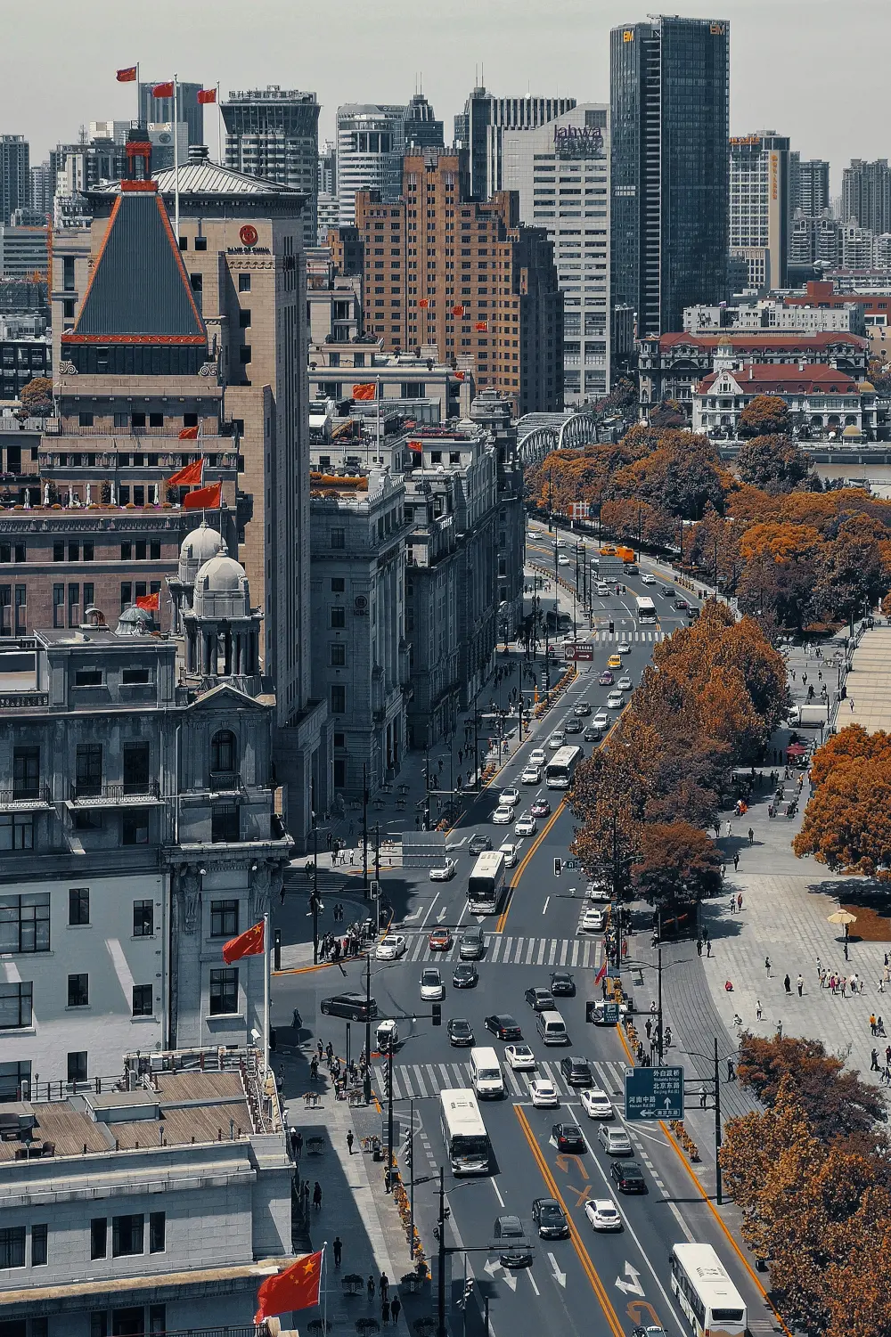 A central Shanghai avenue where historic facades, modern towers, traffic and plane trees share the same urban view