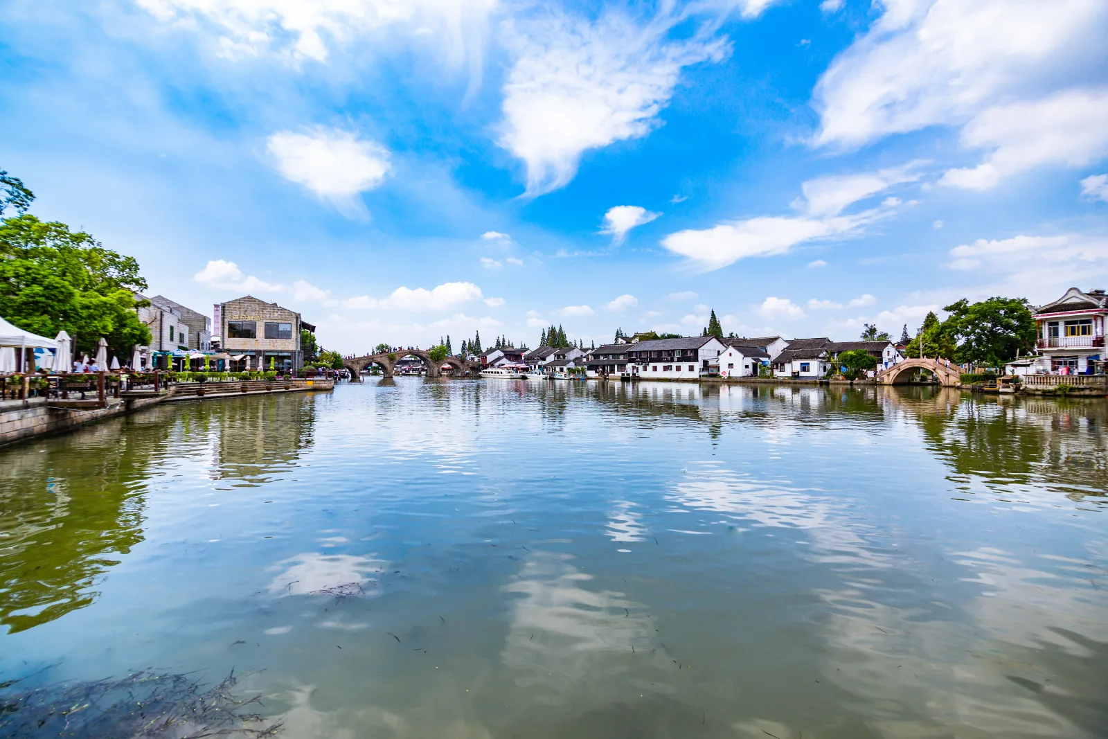 Zhujiajiao water town in Shanghai with canals, bridges, white-walled buildings and a wide blue sky
