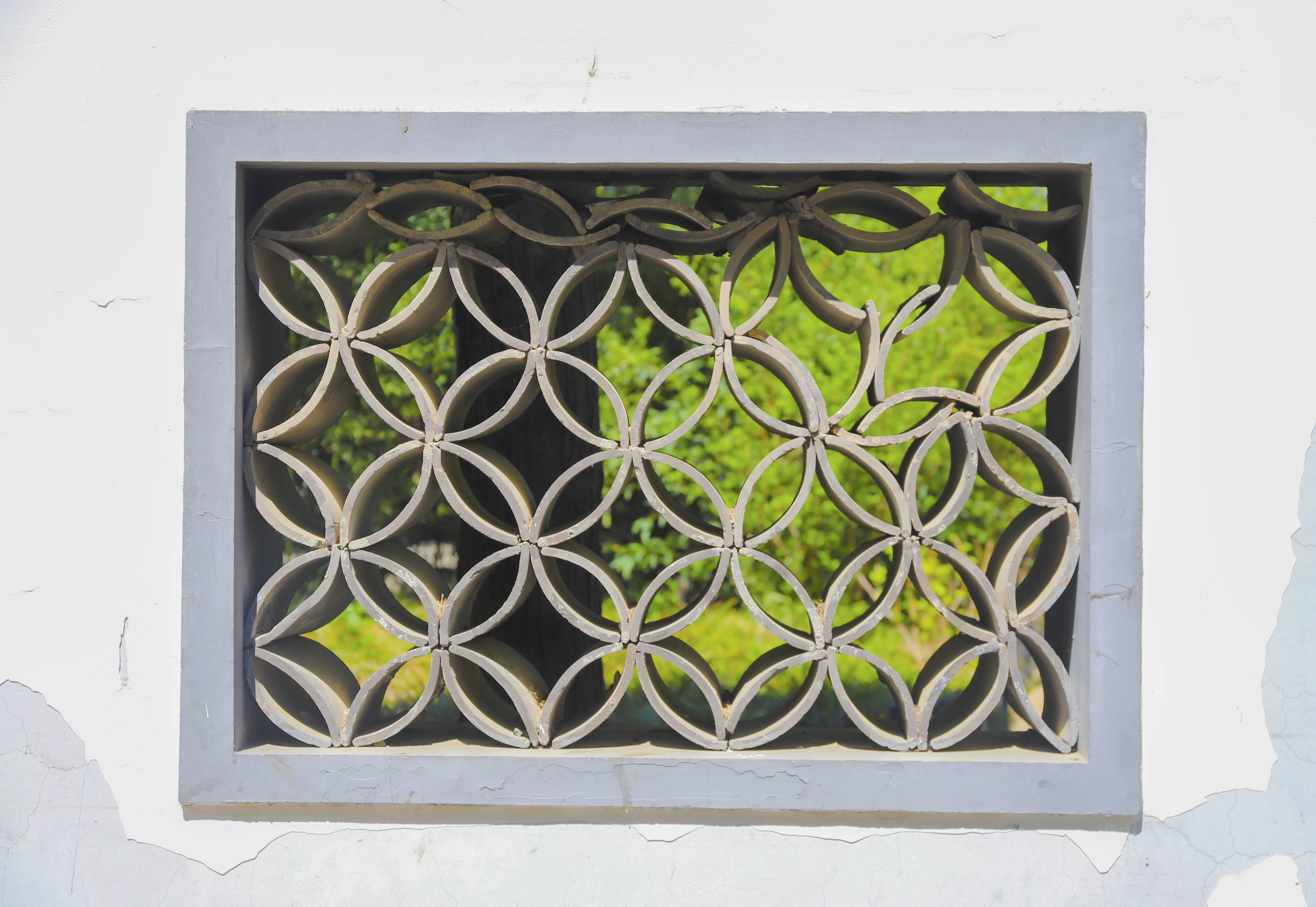 A geometric garden window framing plants and another layer of space in Suzhou