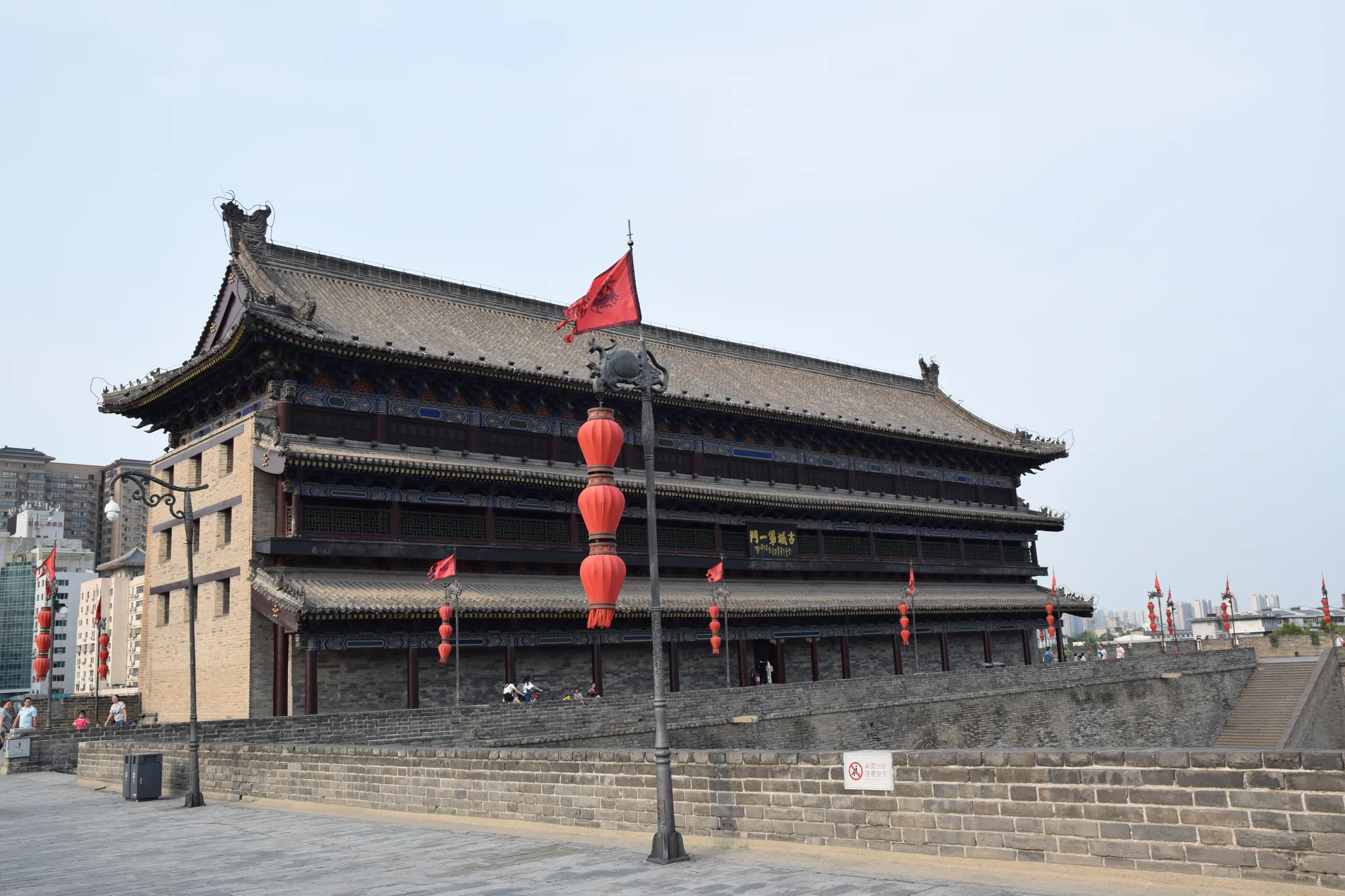 The broad north gate tower and brick ramparts of Xi'an's city wall in daylight